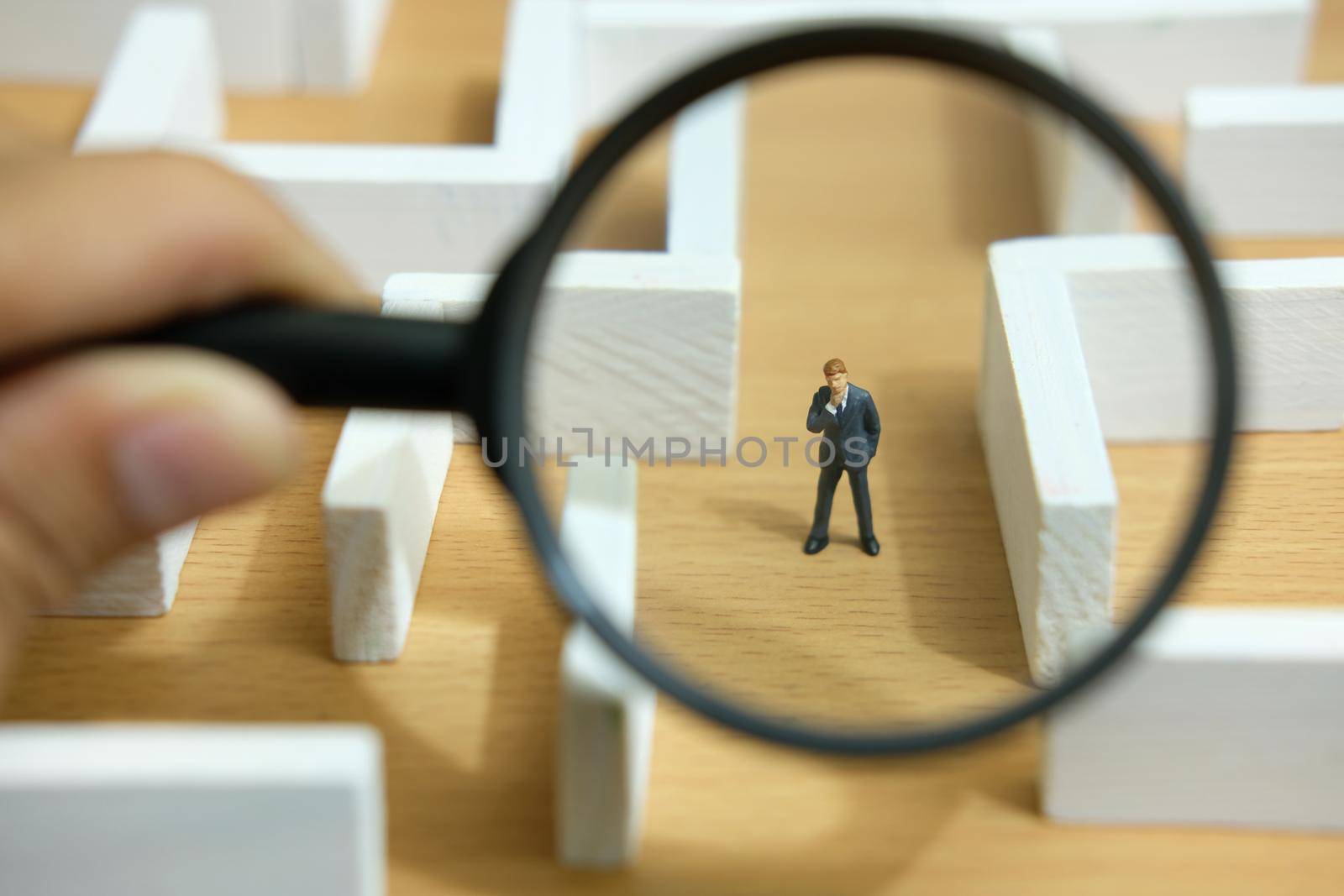 Business strategy conceptual photo - Miniature of businessman looking for solution on a labyrinth maze. Image photo