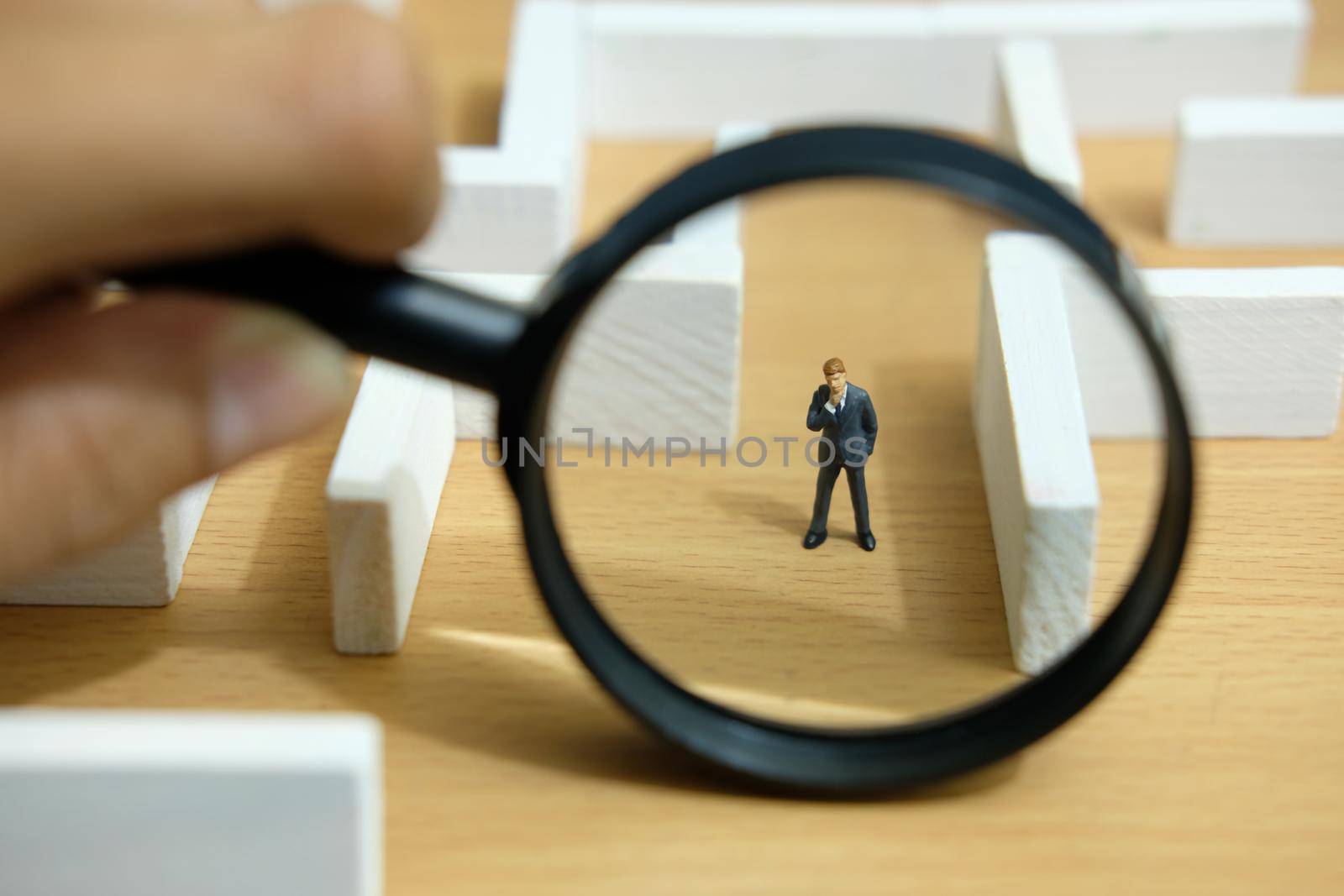 Business strategy conceptual photo - Miniature of businessman looking for solution on a labyrinth maze. Image photo