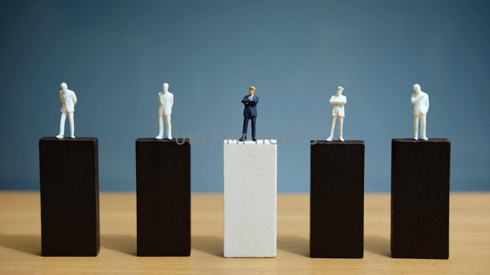 Business strategy conceptual photo – miniature of businessman stands on wooden wall. Image photo