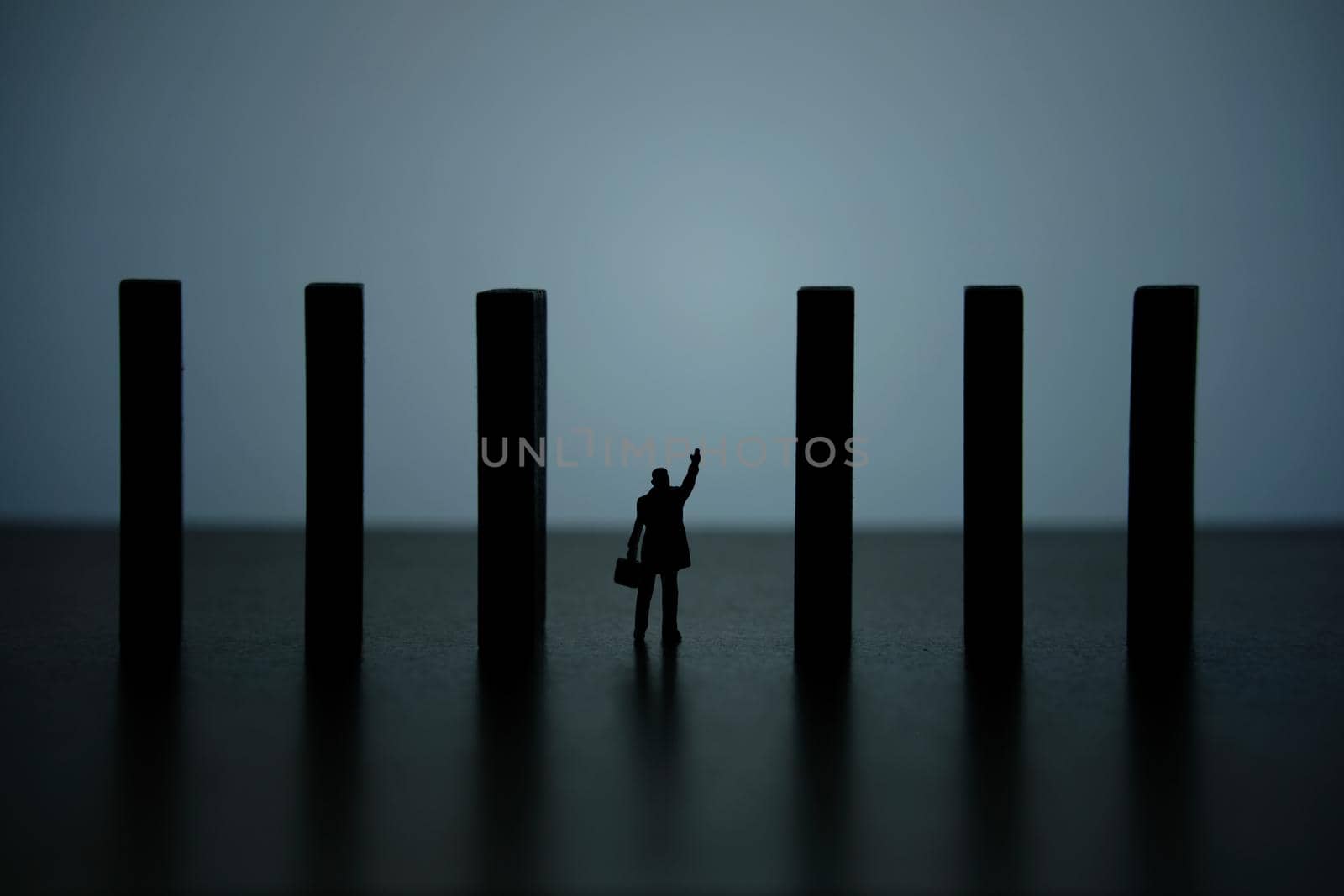 Business strategy conceptual photo – silhouette miniature of businessman walking in the middle of barrier wall. Image photo