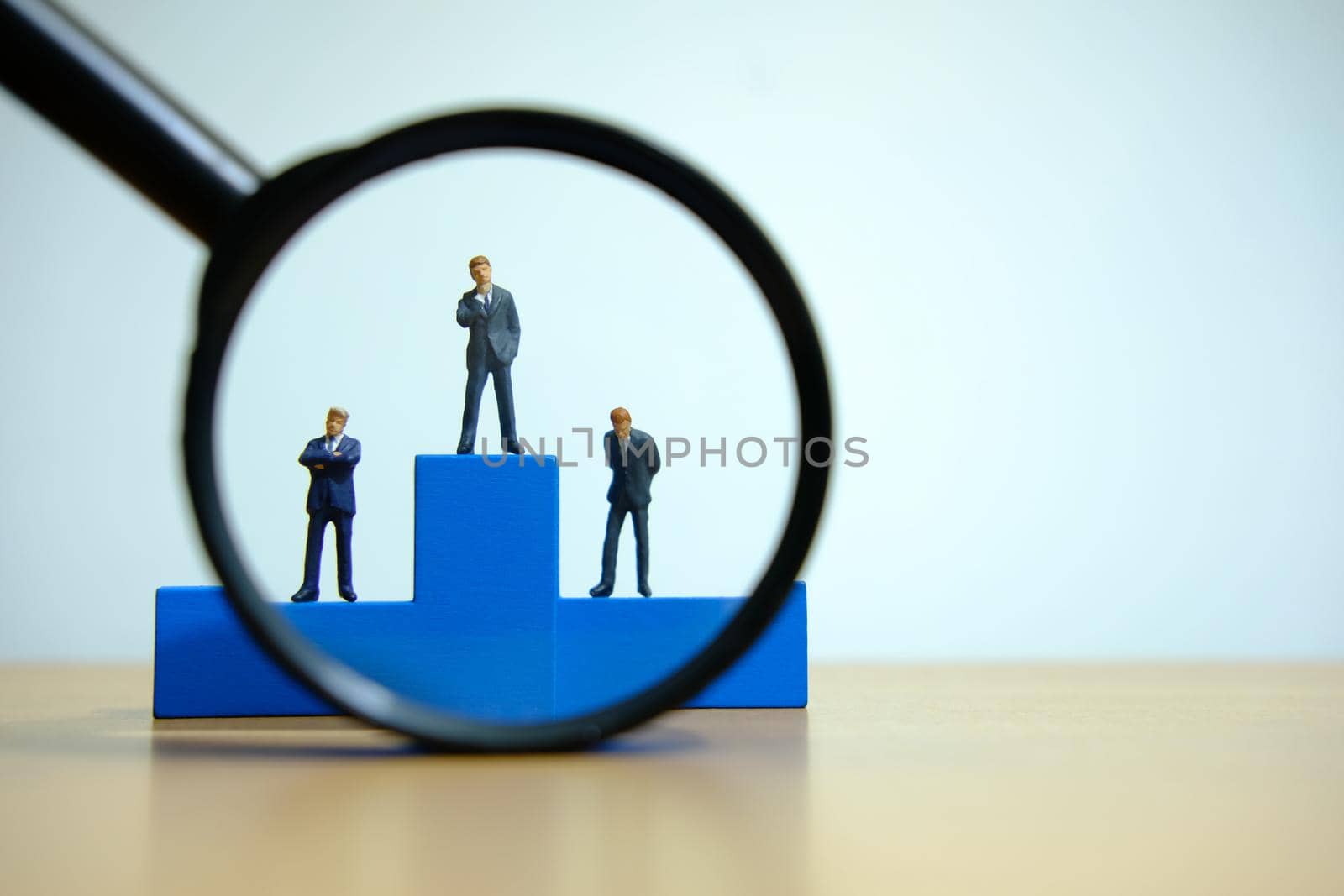 Business conceptual photo – miniature of businessman stands on wooden podium by Macrostud