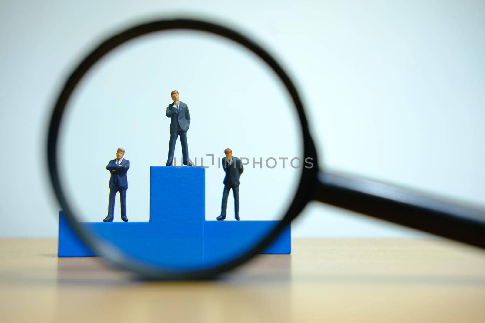 Business conceptual photo – miniature of businessman stands on wooden podium by Macrostud