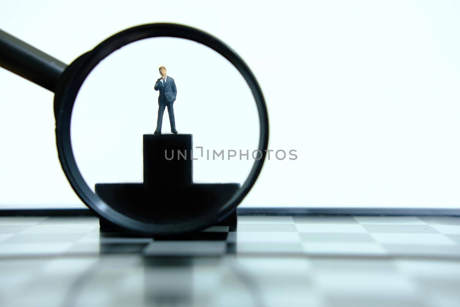 Business conceptual photo – miniature of businessman stands on wooden podium by Macrostud