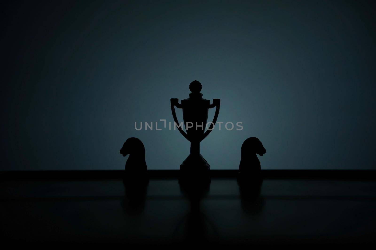 Business strategy conceptual photo – Silhouette of trophy stand in office table with chess pawn by Macrostud