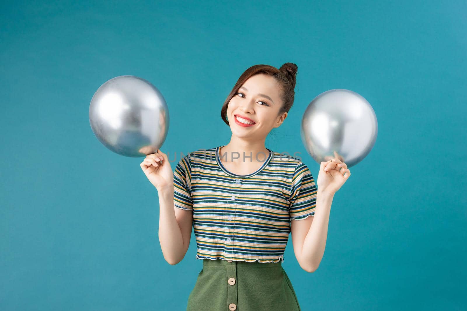 Happy asian girl play with silver balloons