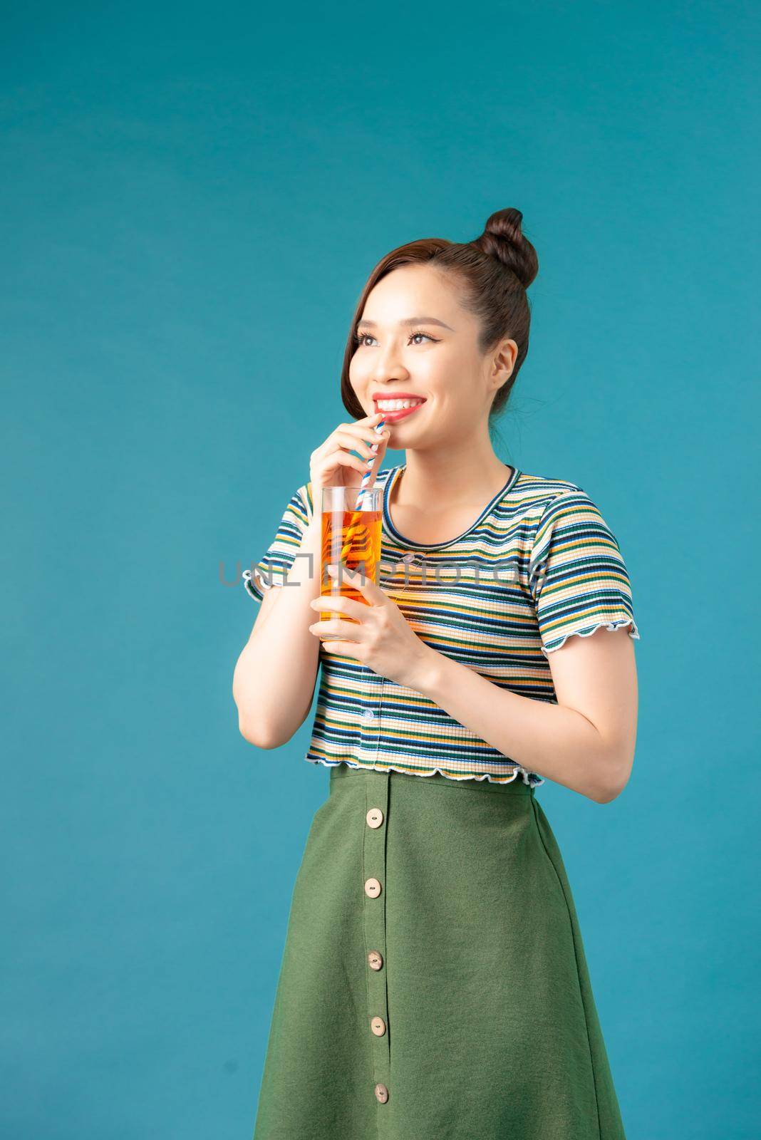 Pretty asian girl drinking a glass of soft-drinks