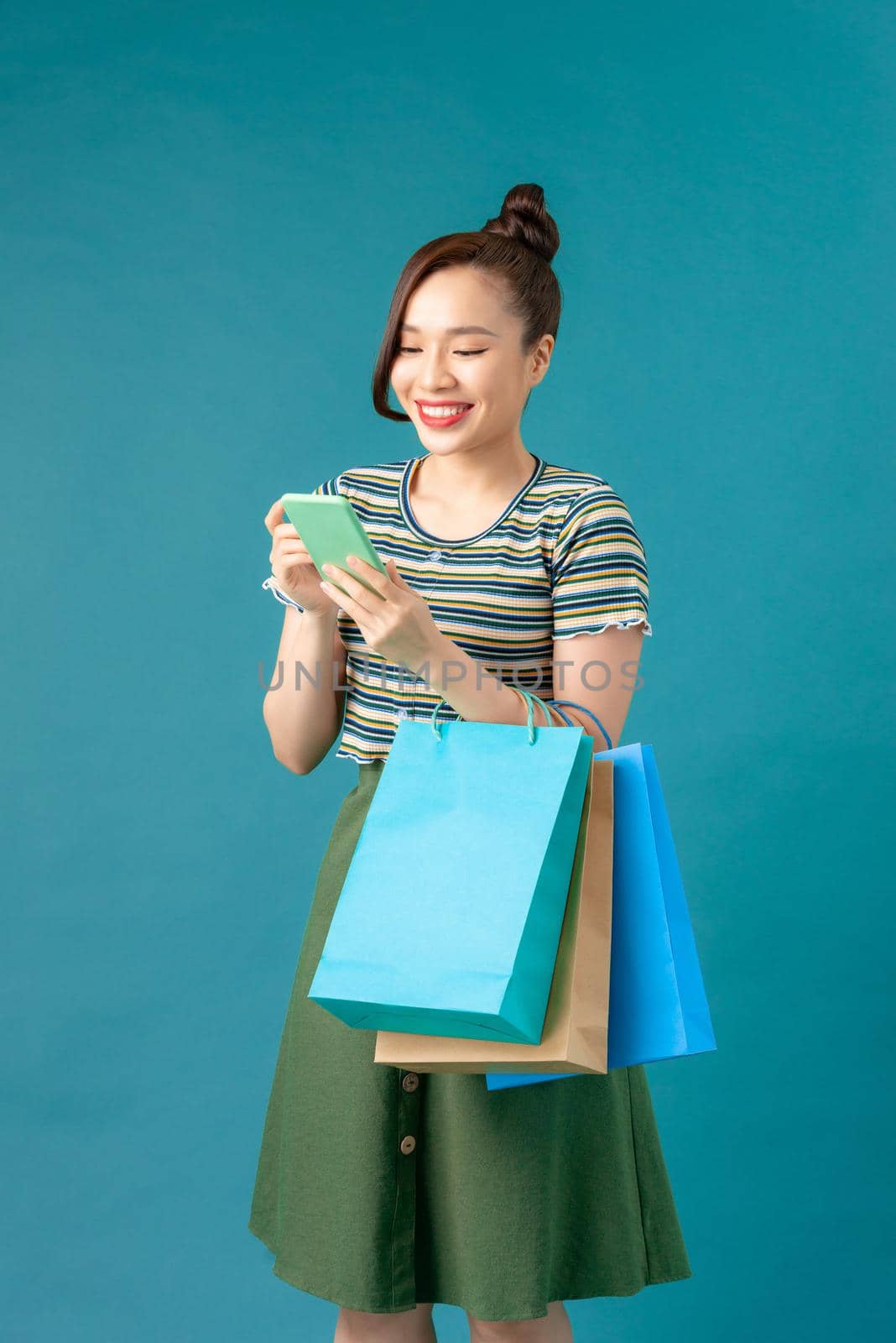 Woman hold with shopping bag and look at smartphone