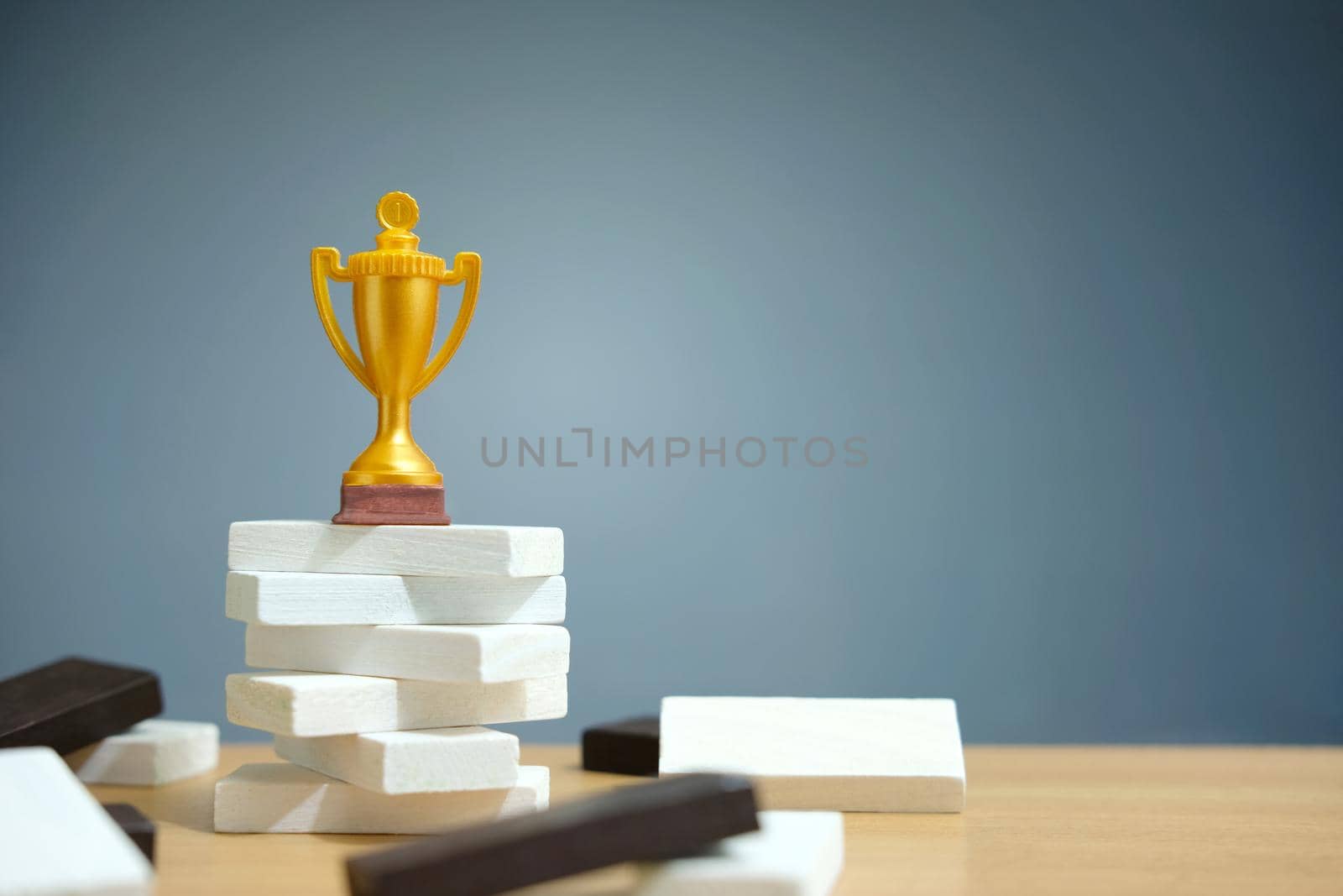 Golden trophy standing on white podium. Image photo