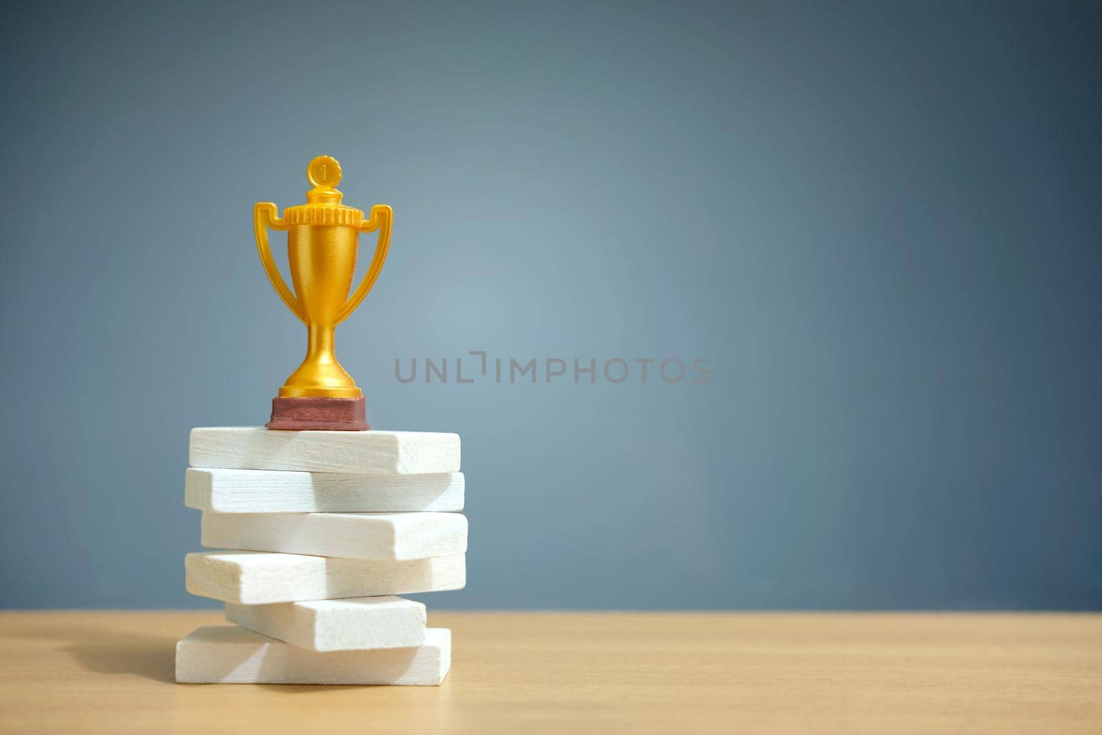 Golden trophy standing on white podium by Macrostud