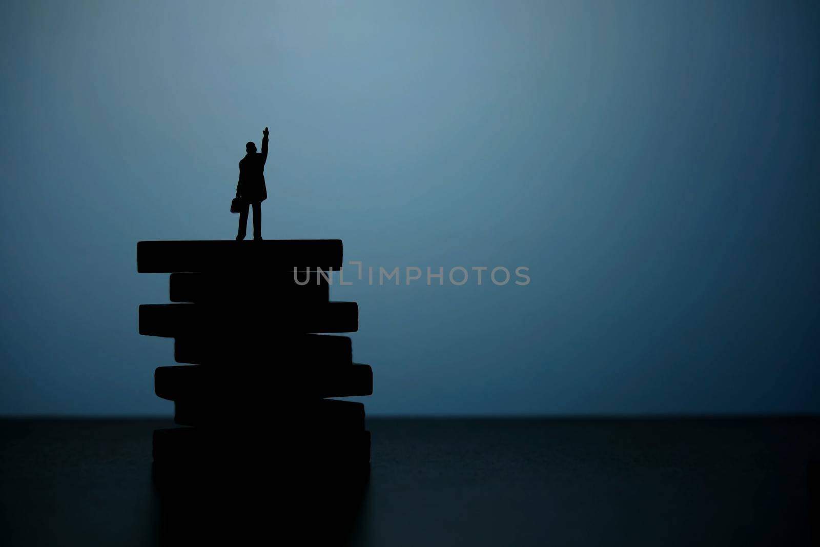 Business strategy conceptual photo - Silhouette of miniature businessman pointing upside above wooden staircase. Image photo