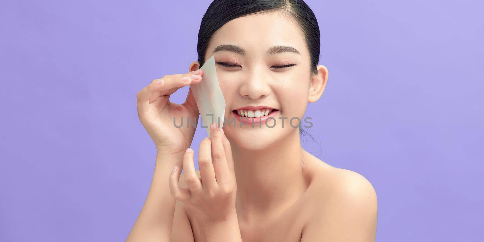 Beautiful Healthy Girl With Nude Makeup Removing Oil From Face Using Blotting Papers by makidotvn