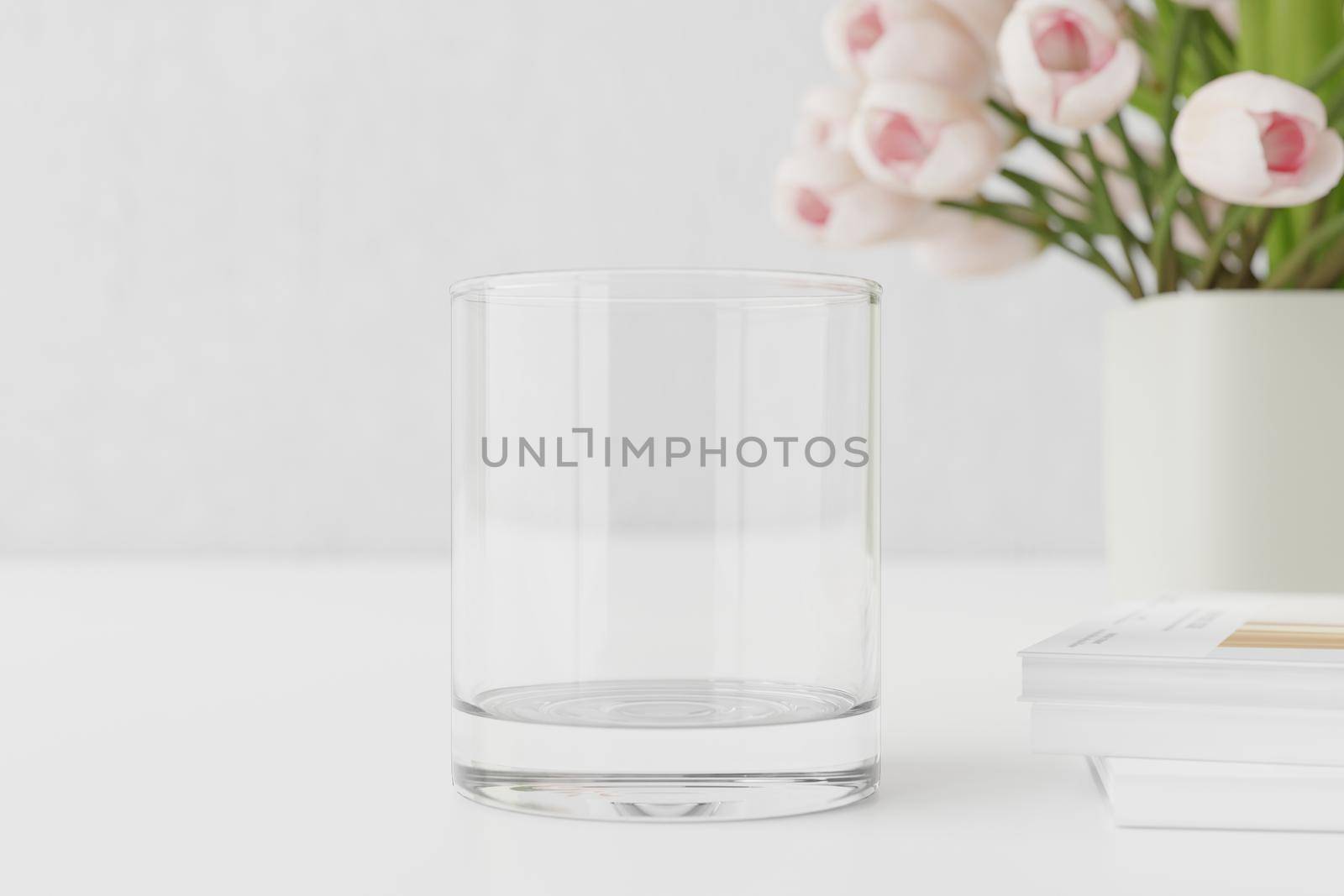 Empty water glass mockup on table with tulips and books.