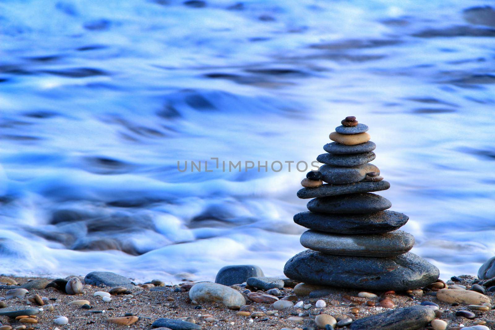 Round stacked stones on the shore by soniabonet
