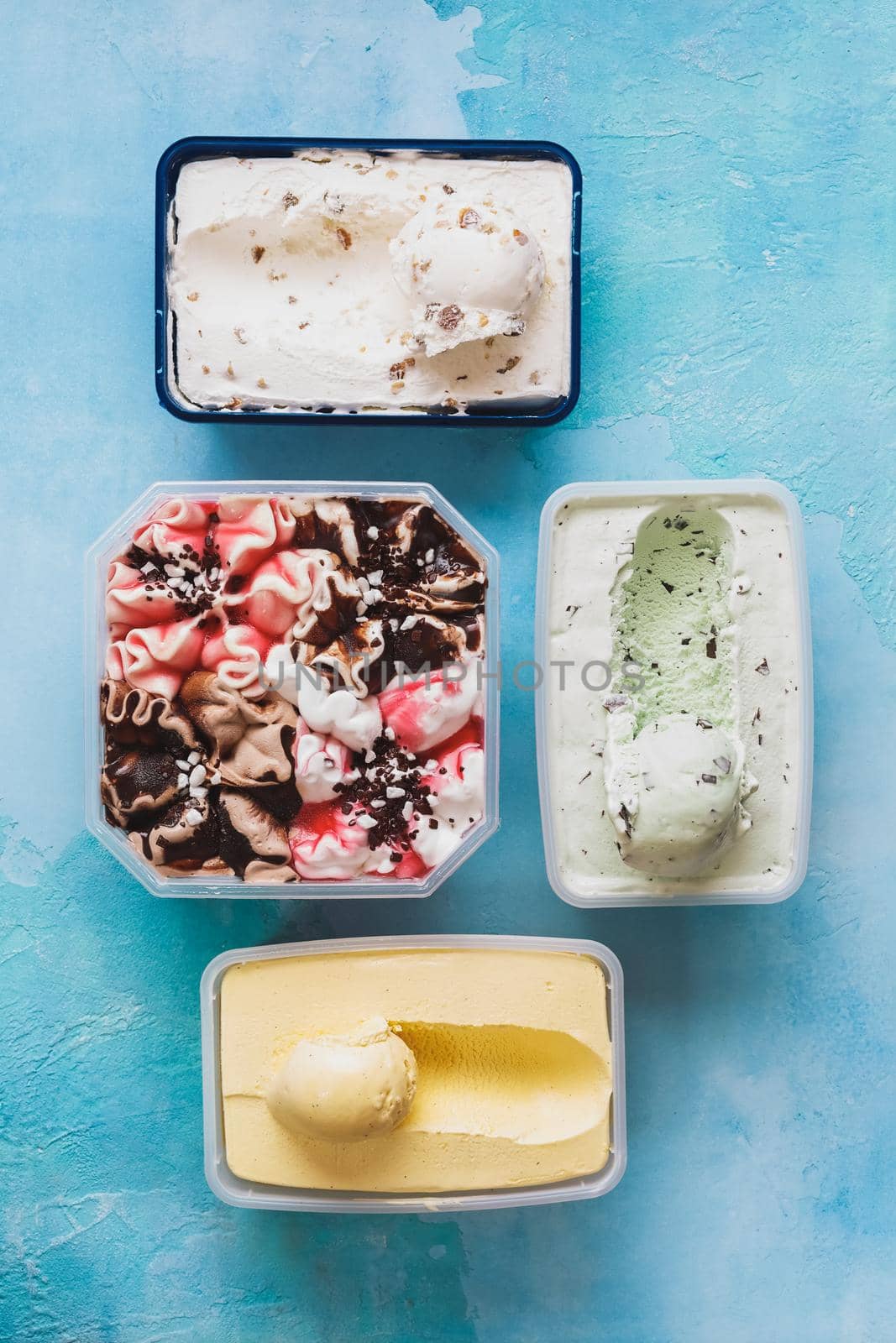 Melted ice cream in individual containers featuring chocolate , vanilla bean , fruit and matcha mint ice cream. Top view, blank space by Slast20