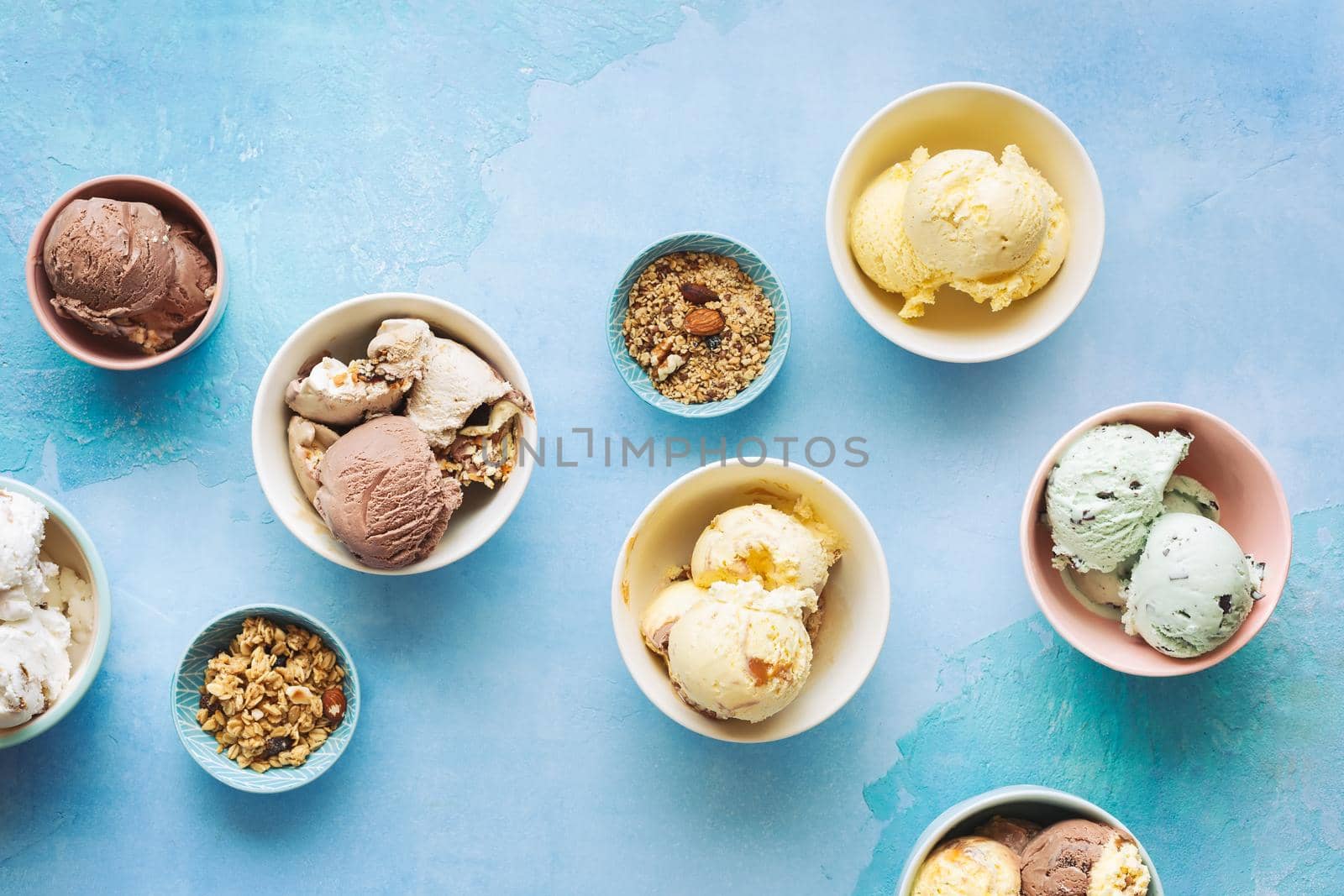 Various ice cream desserts in bowls on rustic blue background, Top view, blank space by Slast20