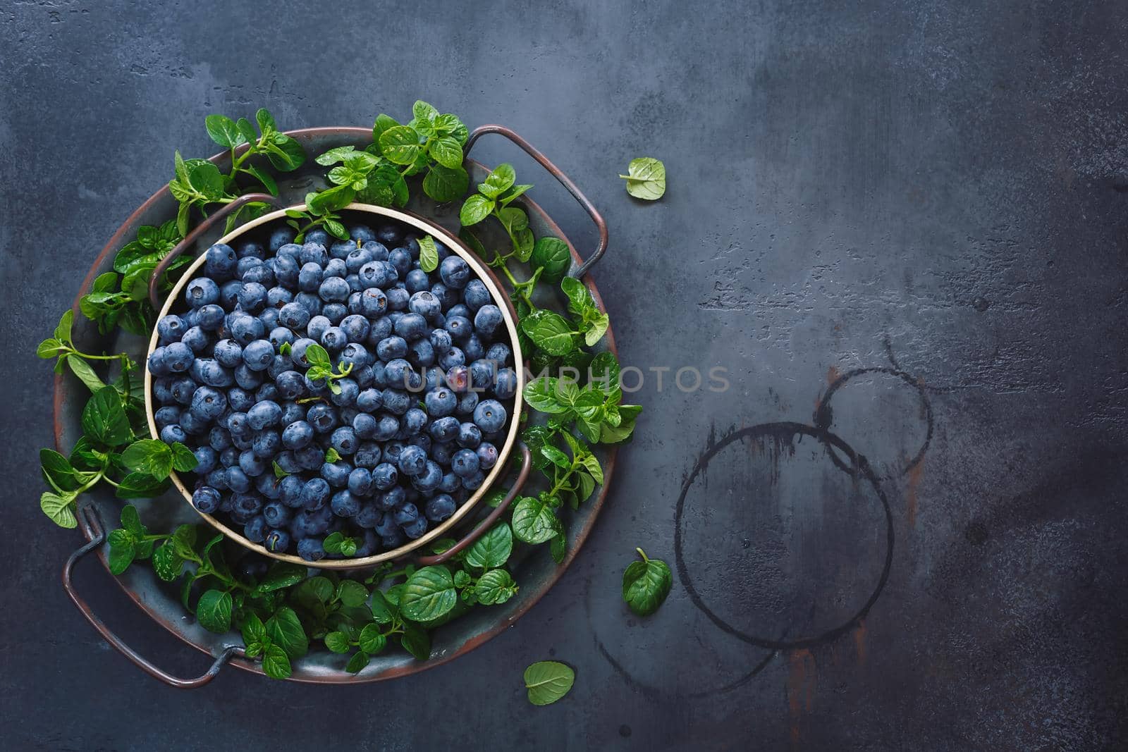Plate of blueberries. Plate full of  ripe blueberries placed on black  rustic background. Top view, blank space by Slast20