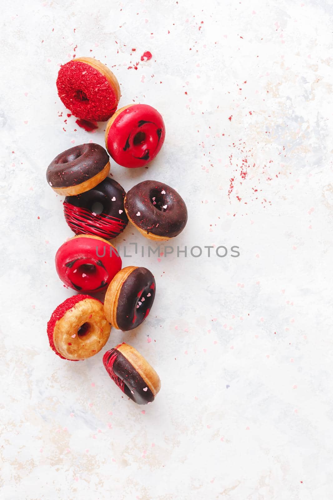 Valentine's Day Donuts. Colorful mini  donuts with chocolate, icing and sugar sprinkles on rustic wooden background by Slast20