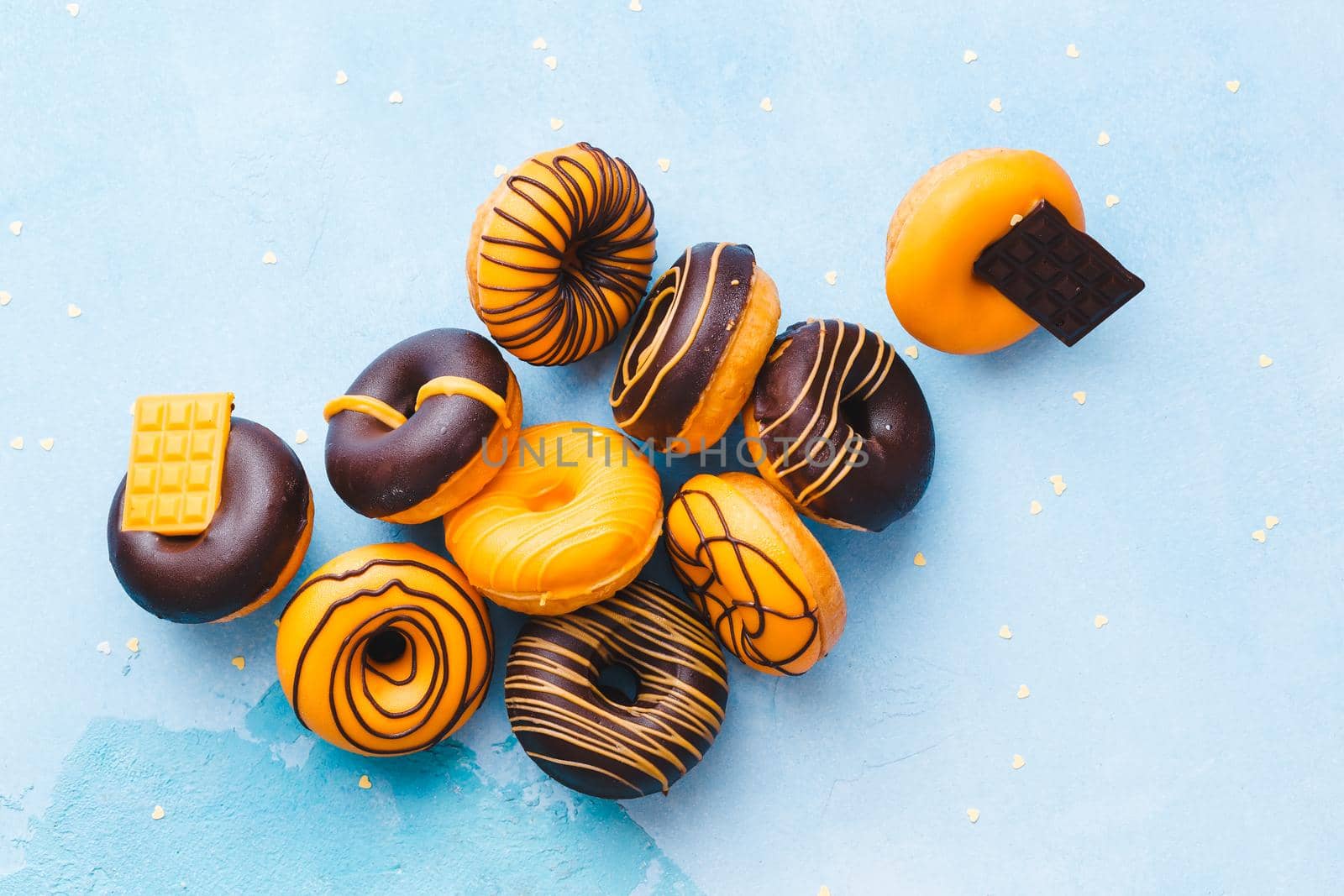 Tasty Glazed Donuts.  Mini  donuts with chocolate on rustic blue background. Top view, blank space by Slast20