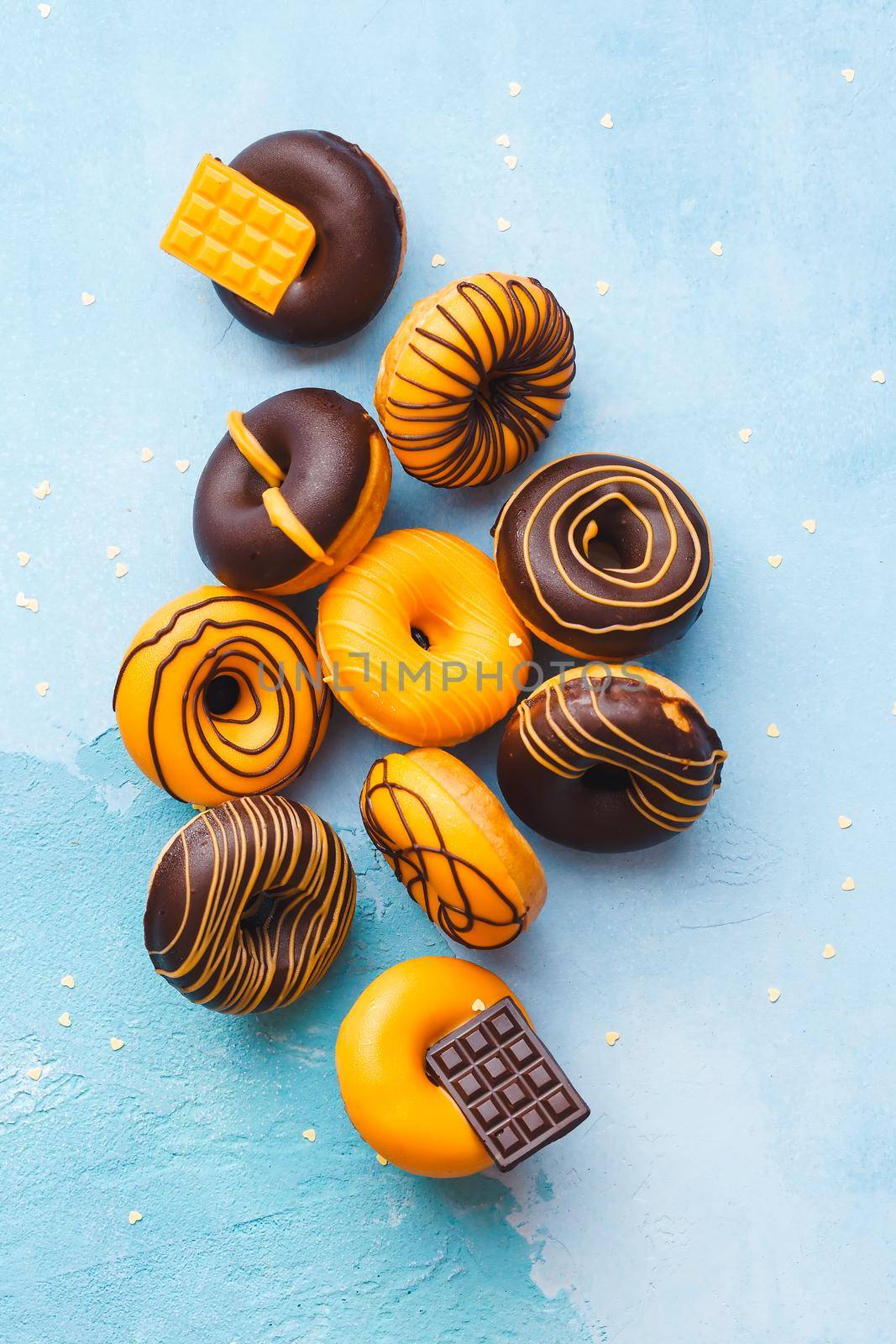 Tasty Glazed Donuts.  Mini  donuts with chocolate on rustic blue background. Top view, blank space by Slast20