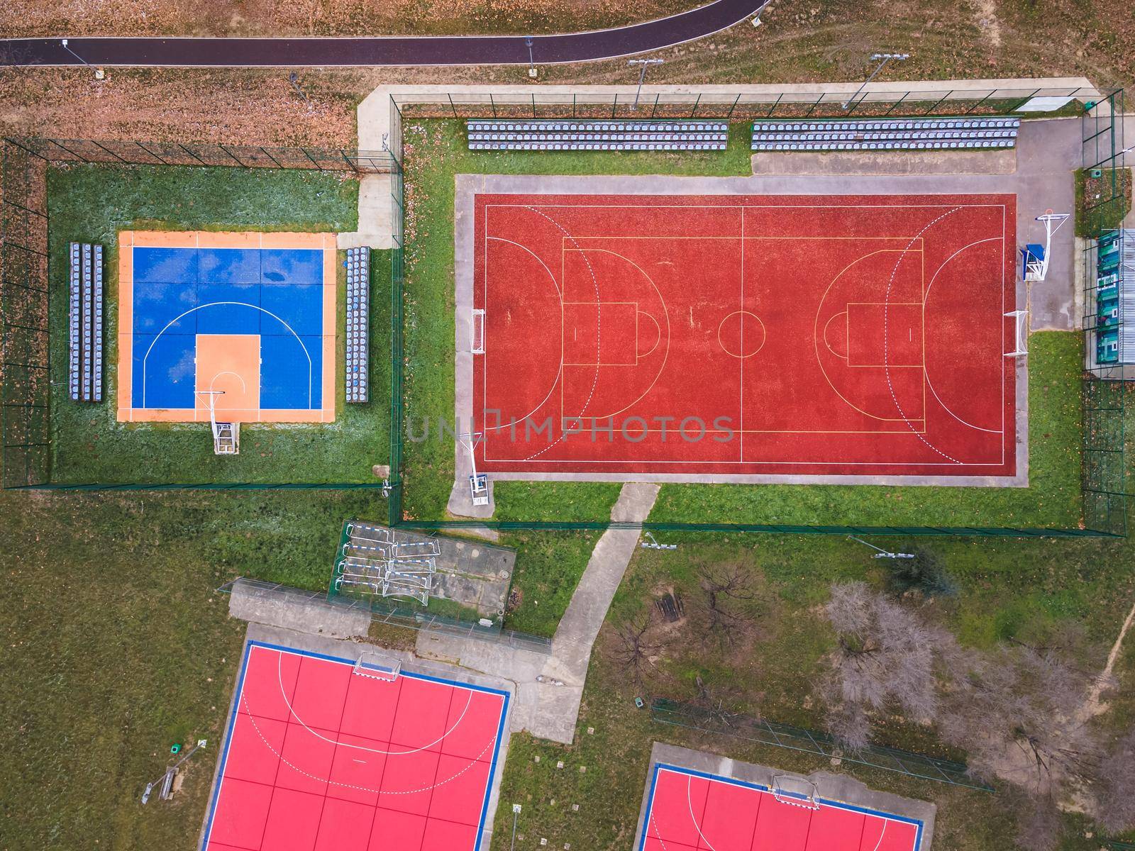 Colorful basketball, volleyball and soccer grounds. A red ,orange and blue colored outdoor sports grounds for basketball, handball and soccer from above.