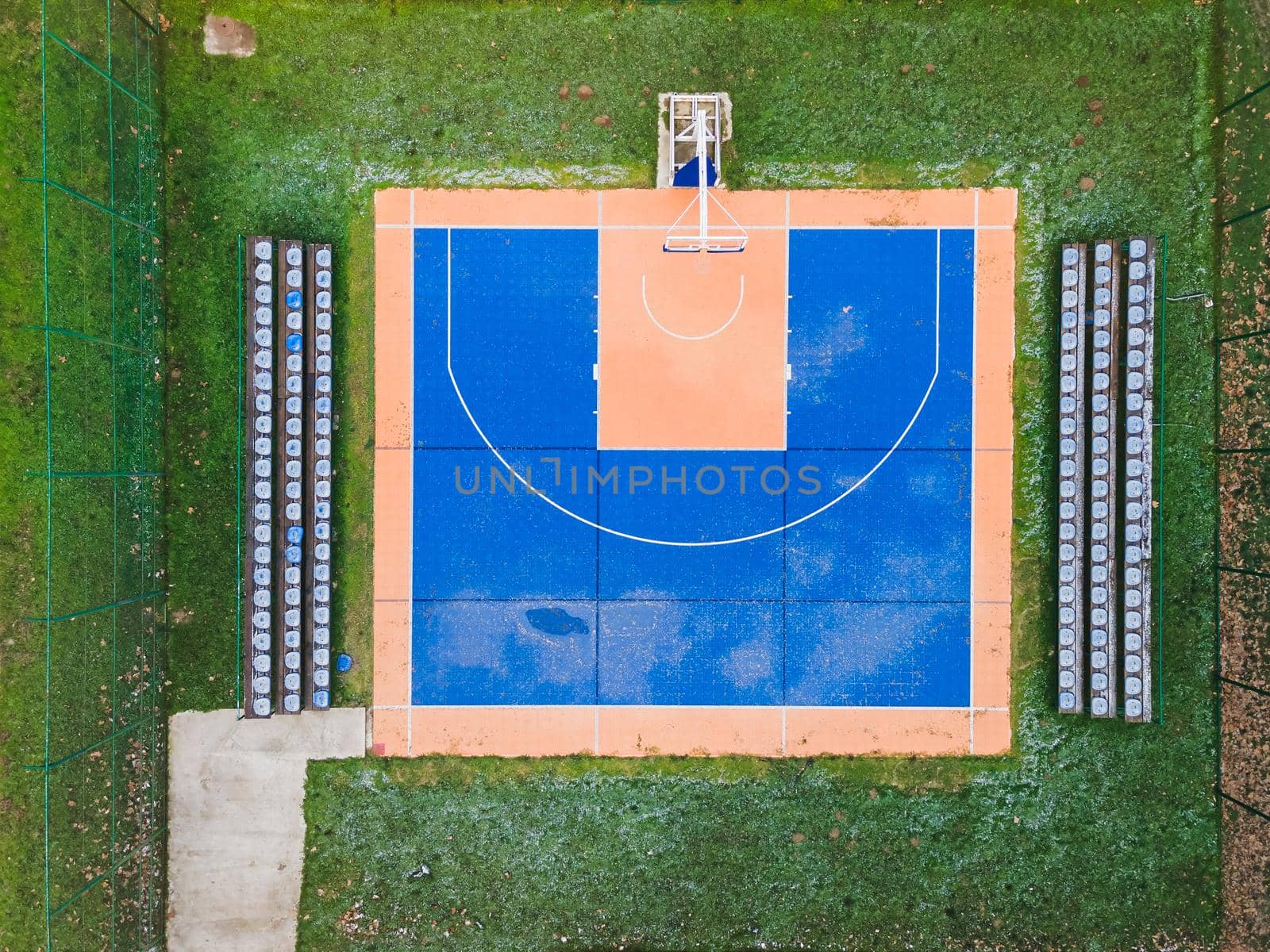 Colorful basketball  field from above. Outdoor sports ground with blue and orange surface for playing basketball,  lamps and benches for spectators by Slast20