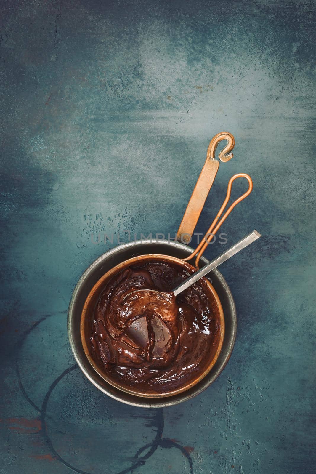 Melted chocolate in a copper pan. Top view, blank space