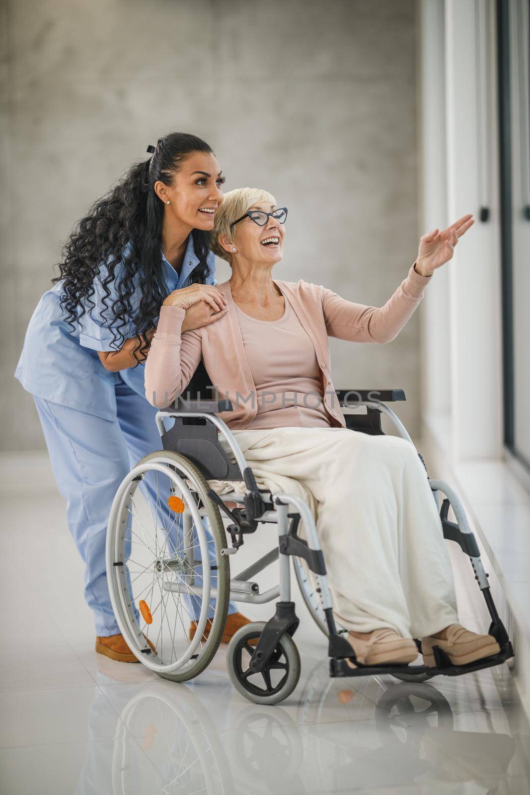 Shot of a caregiver caring a senior female wheelchair-bound patient.