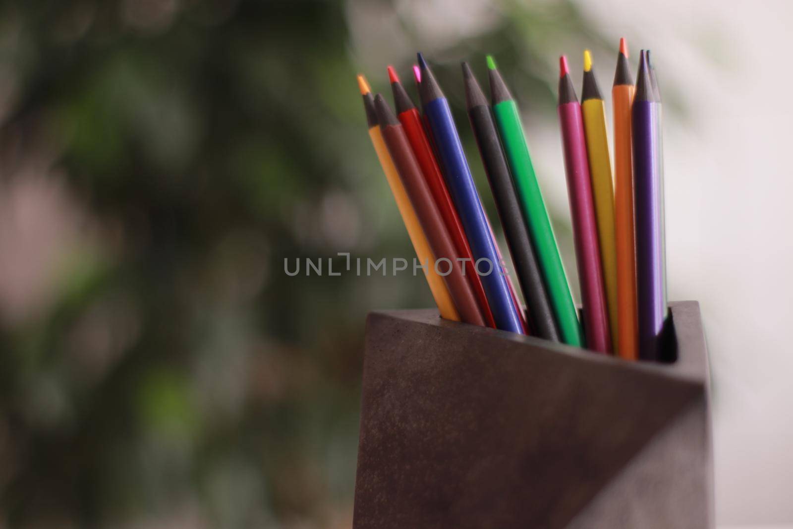 A close up of pencils in a concrete organizer. Colors