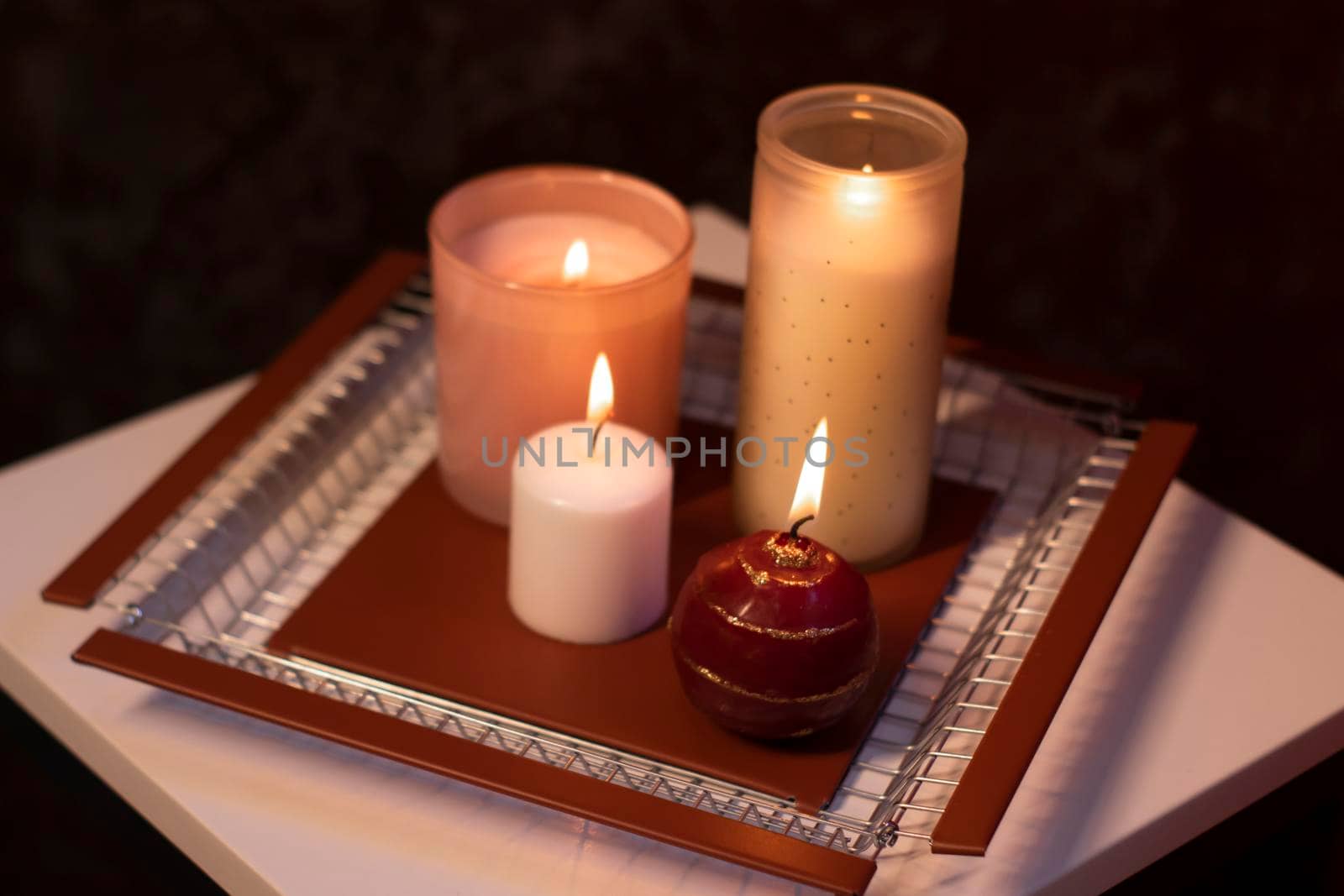 set of candles - pink and red - on a handmade metal tray. home interior and decor. High quality photo