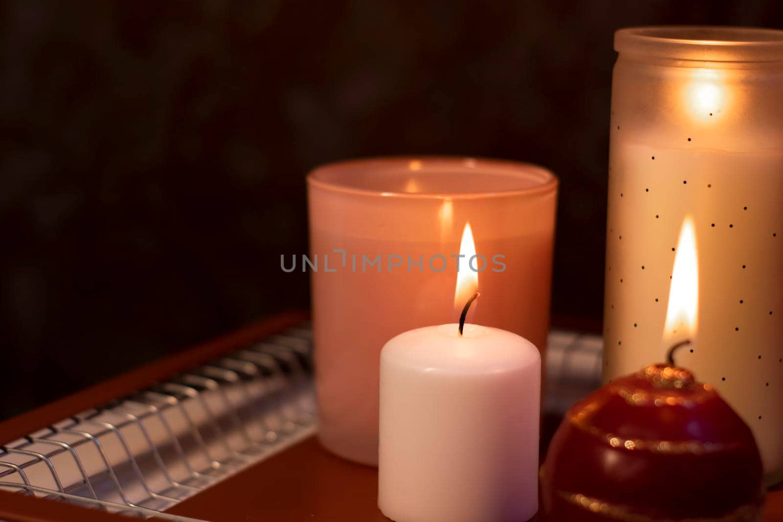 set of candles - pink and red - on a handmade metal tray. home interior and decor. High quality photo