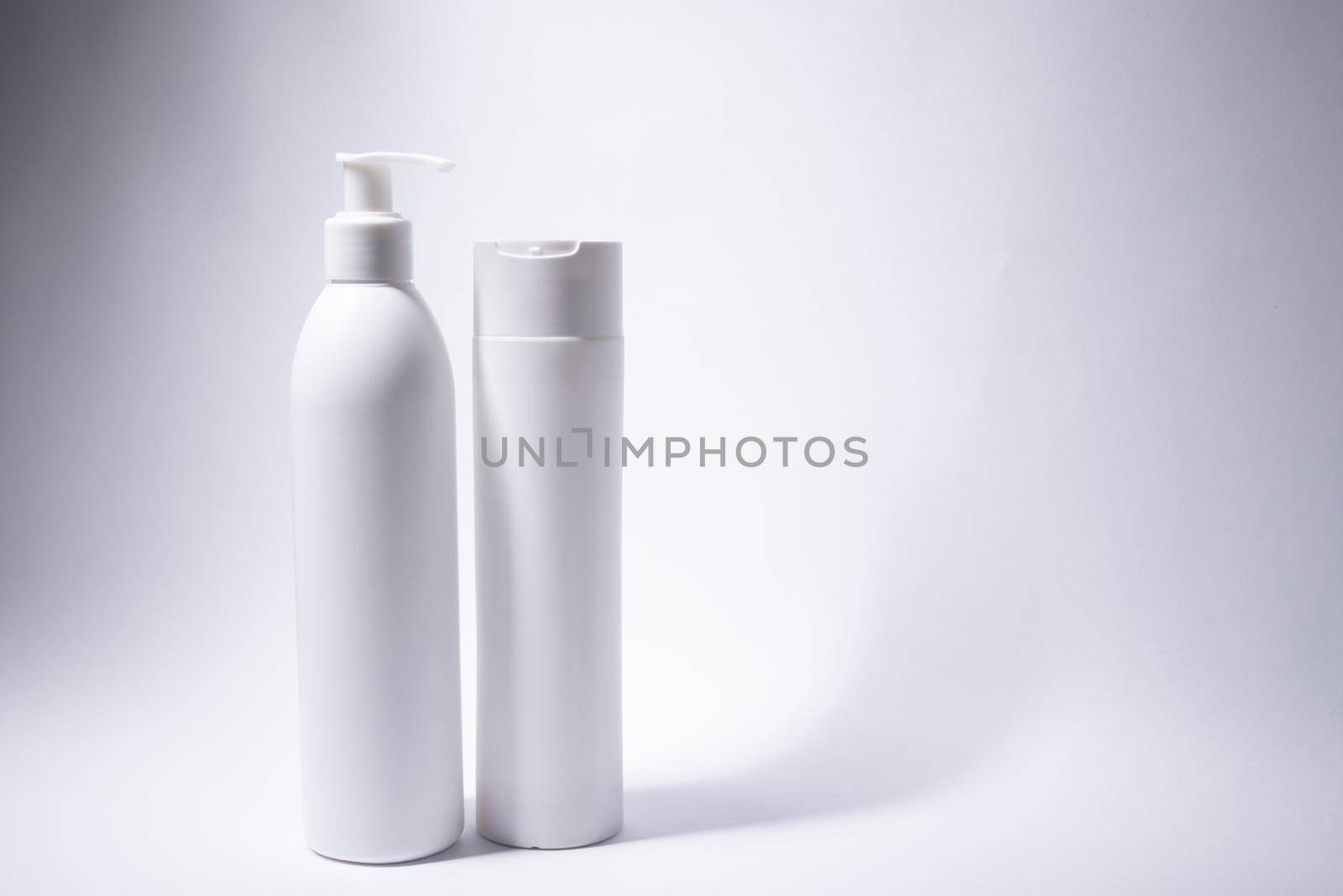 two white shampoo bottles and no label. body care and beauty concept. Copy space. High quality photo