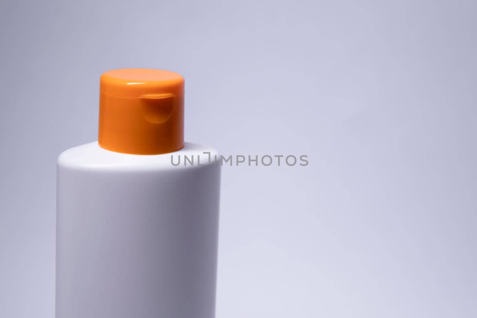 a yellow shampoo bottle with yellow neck and no label. body care and beauty concept. Copy space. High quality photo