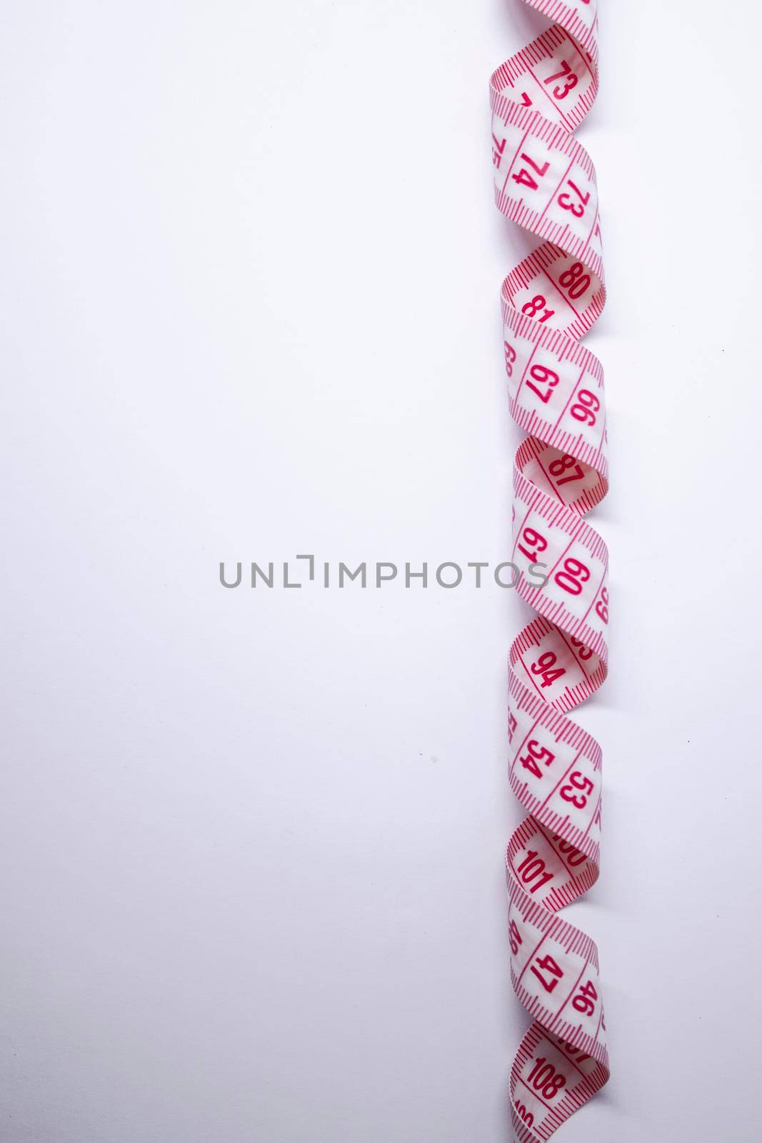 Red measuring tape on white background. Loss weight concept. Top view. Copy space. Isolated by oliavesna