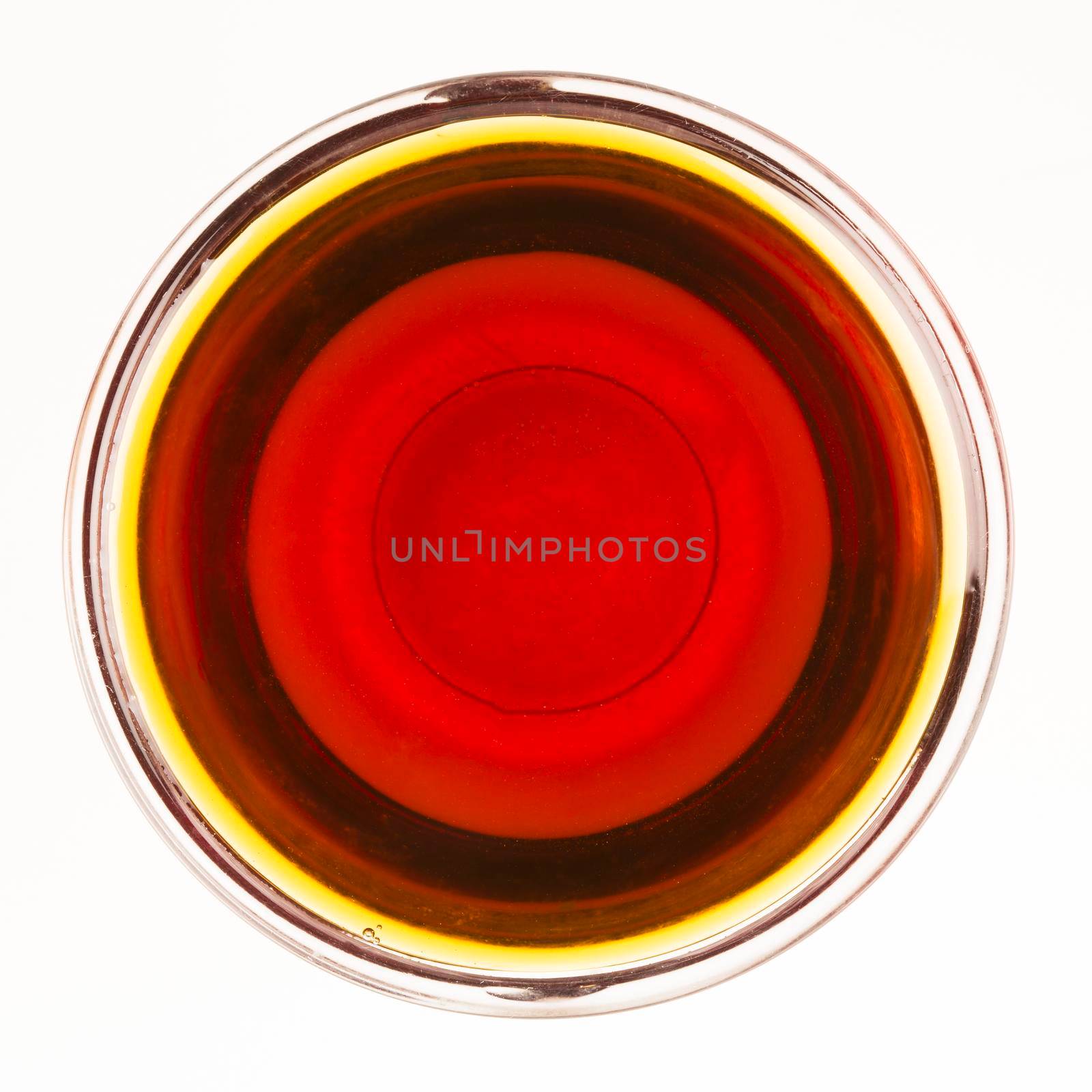 Bowl of maple syrup isolated on a white background.