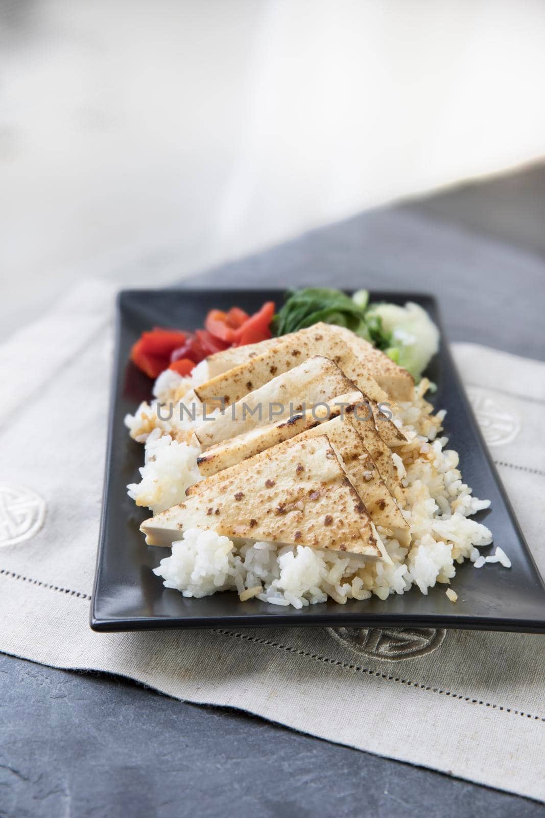 Grilled tofu on a bed of rice with vegetables