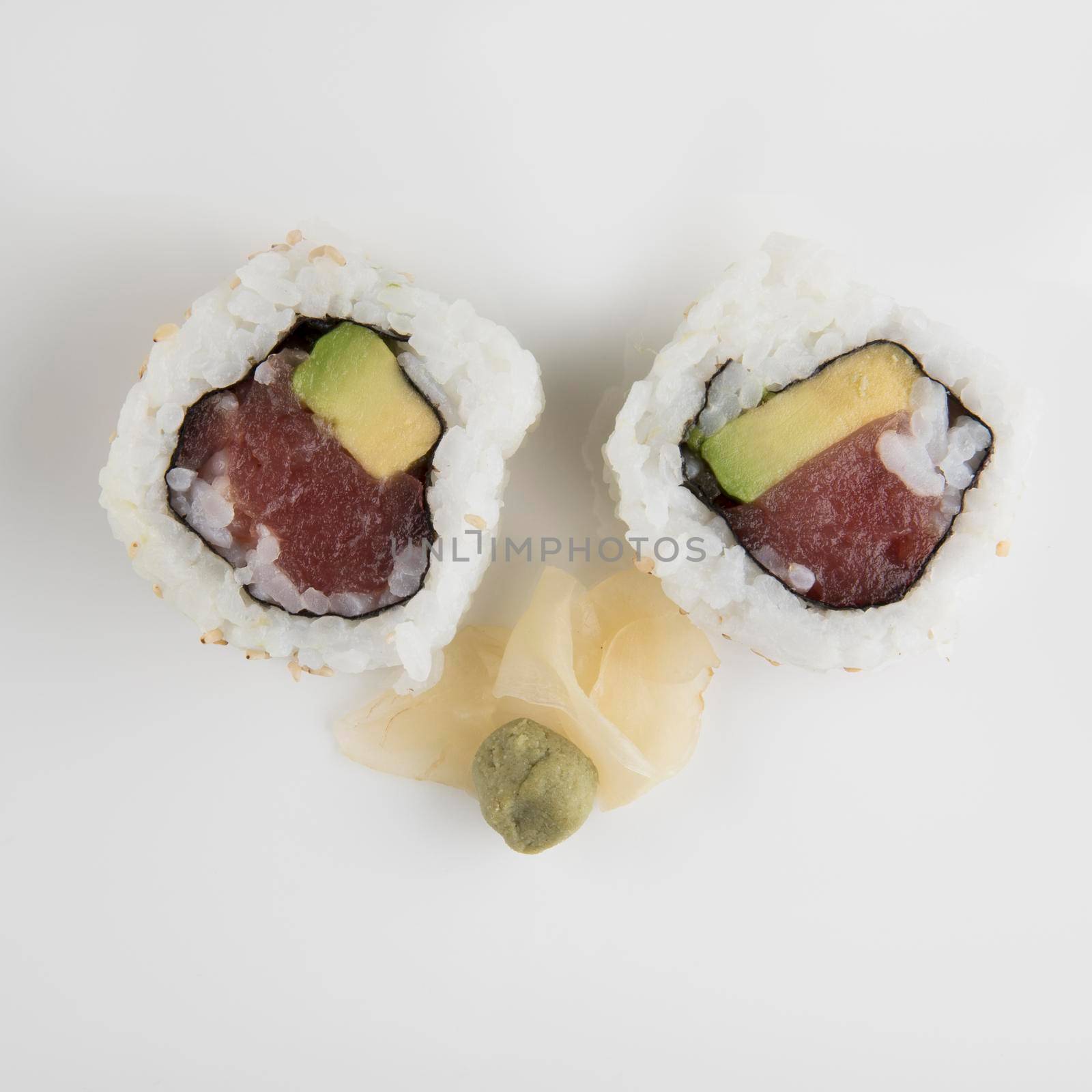 Fresh tuna and avocado uramaki sushi rolls with wasabi and ginger.