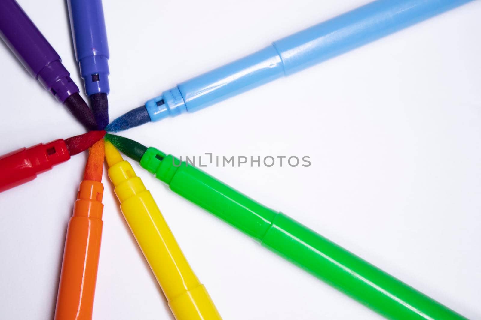 a bunch of colored markers laid out in rainbow order. stationery concept. copy space. isolated. High quality photo