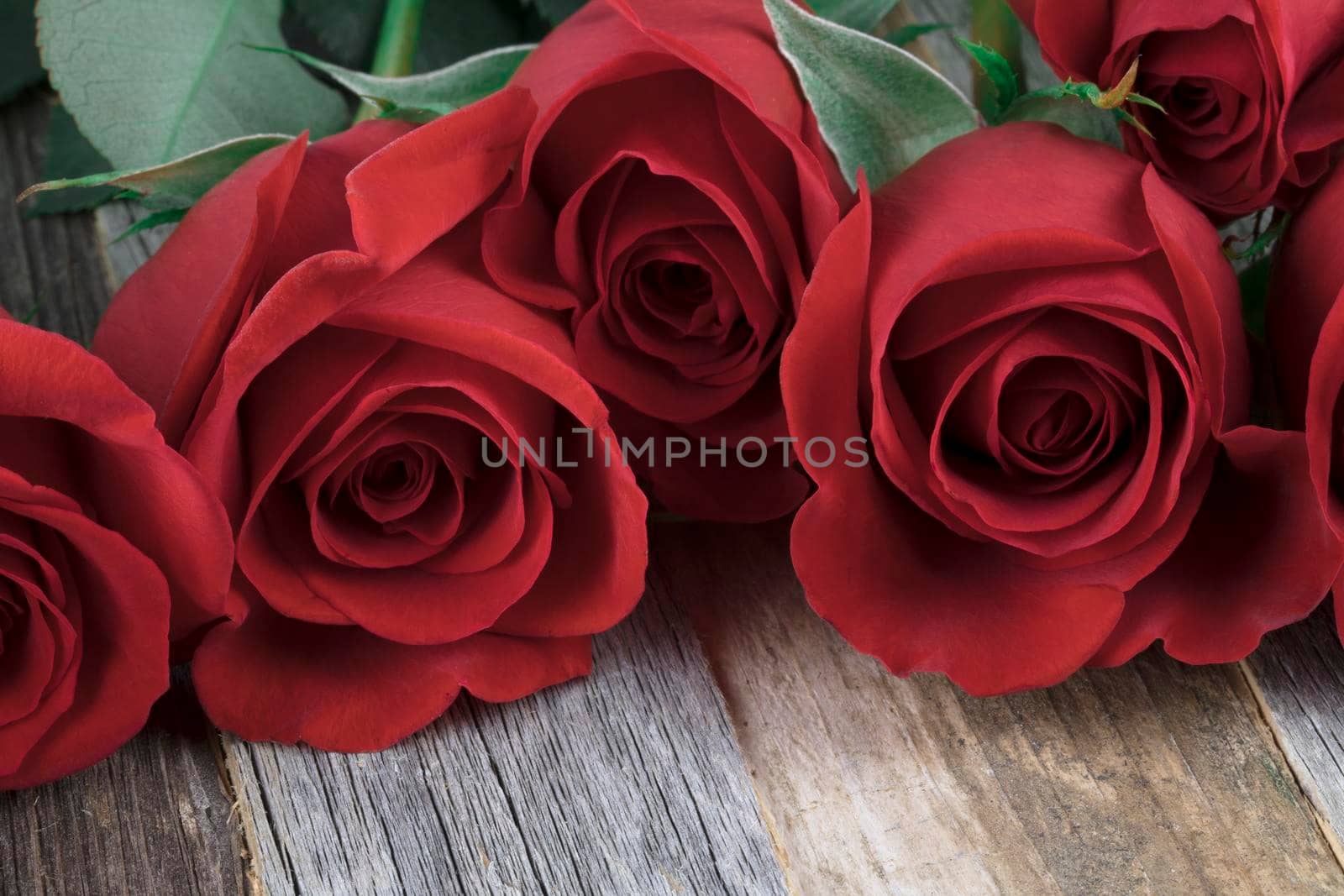 Close up of red roses on wooden table.