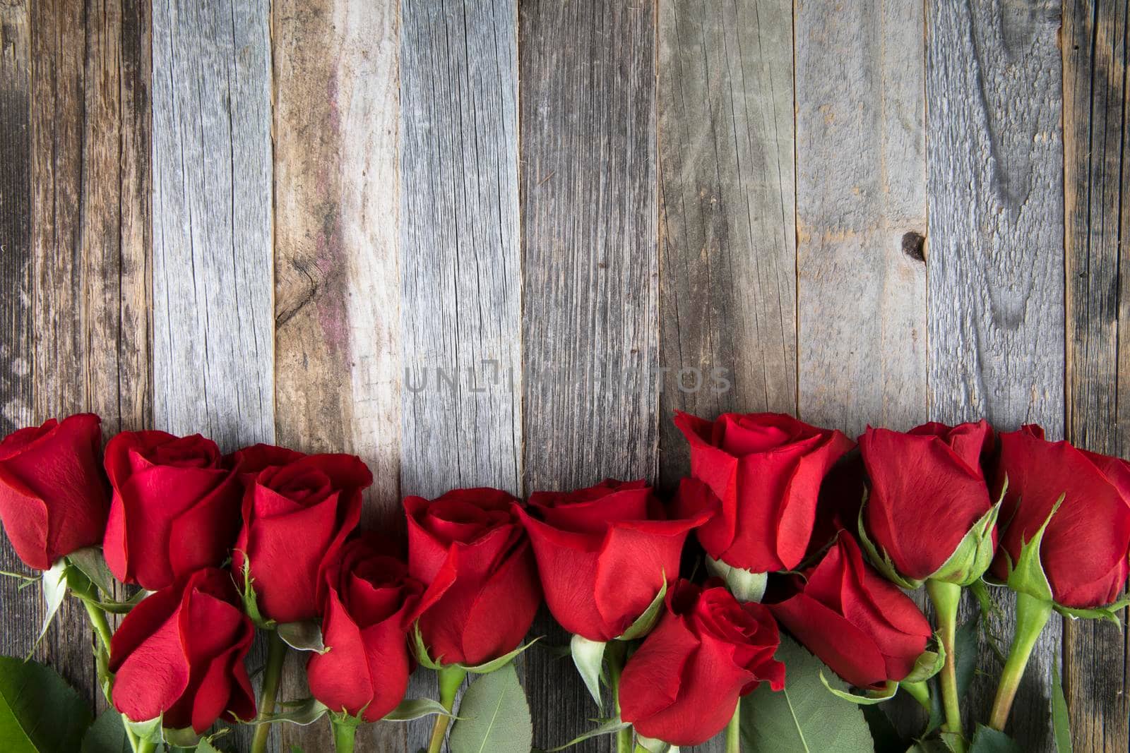 Romantic red roses for a special occasions on a wooden background with copy space.