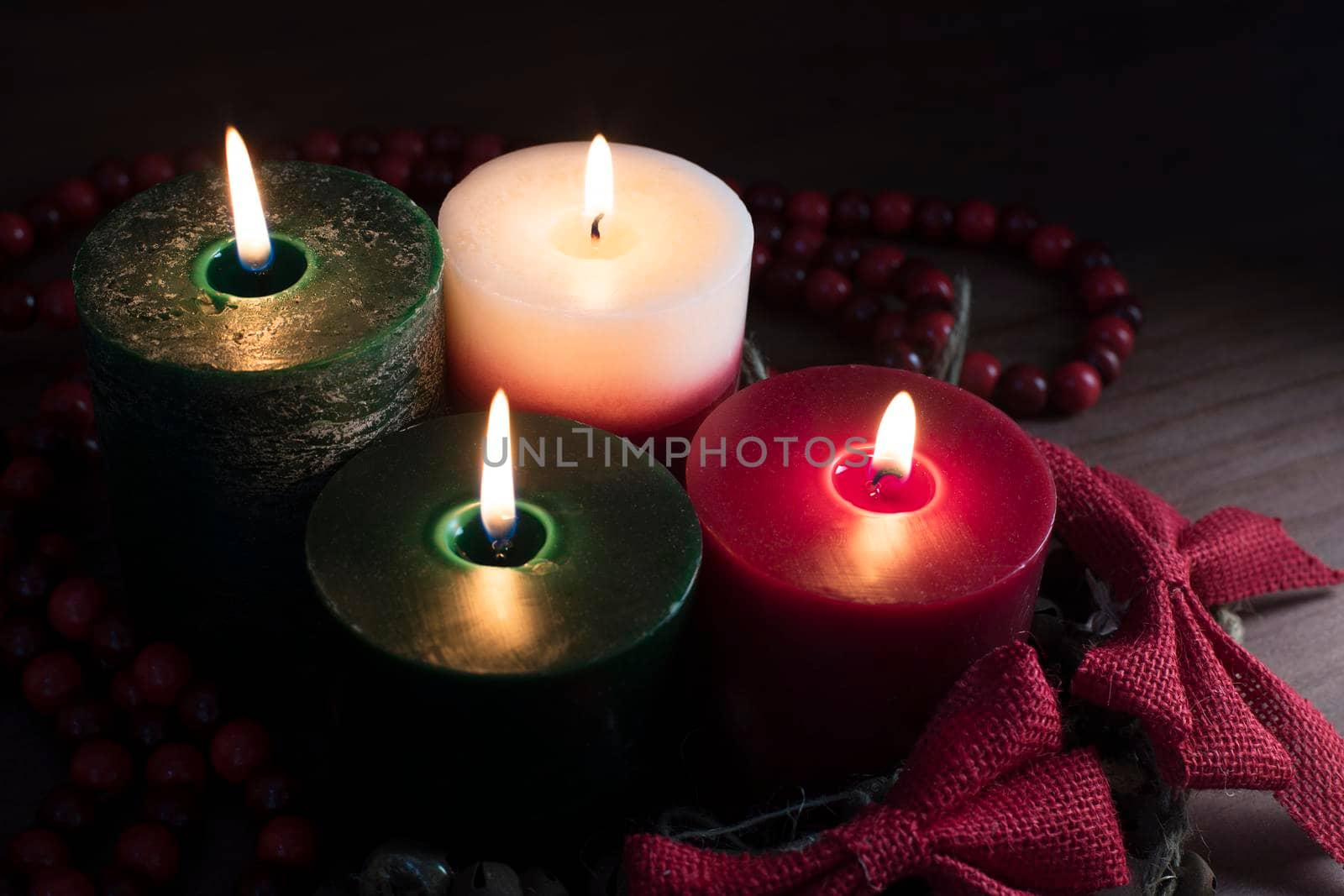 Four Christmas candles with red bows.
