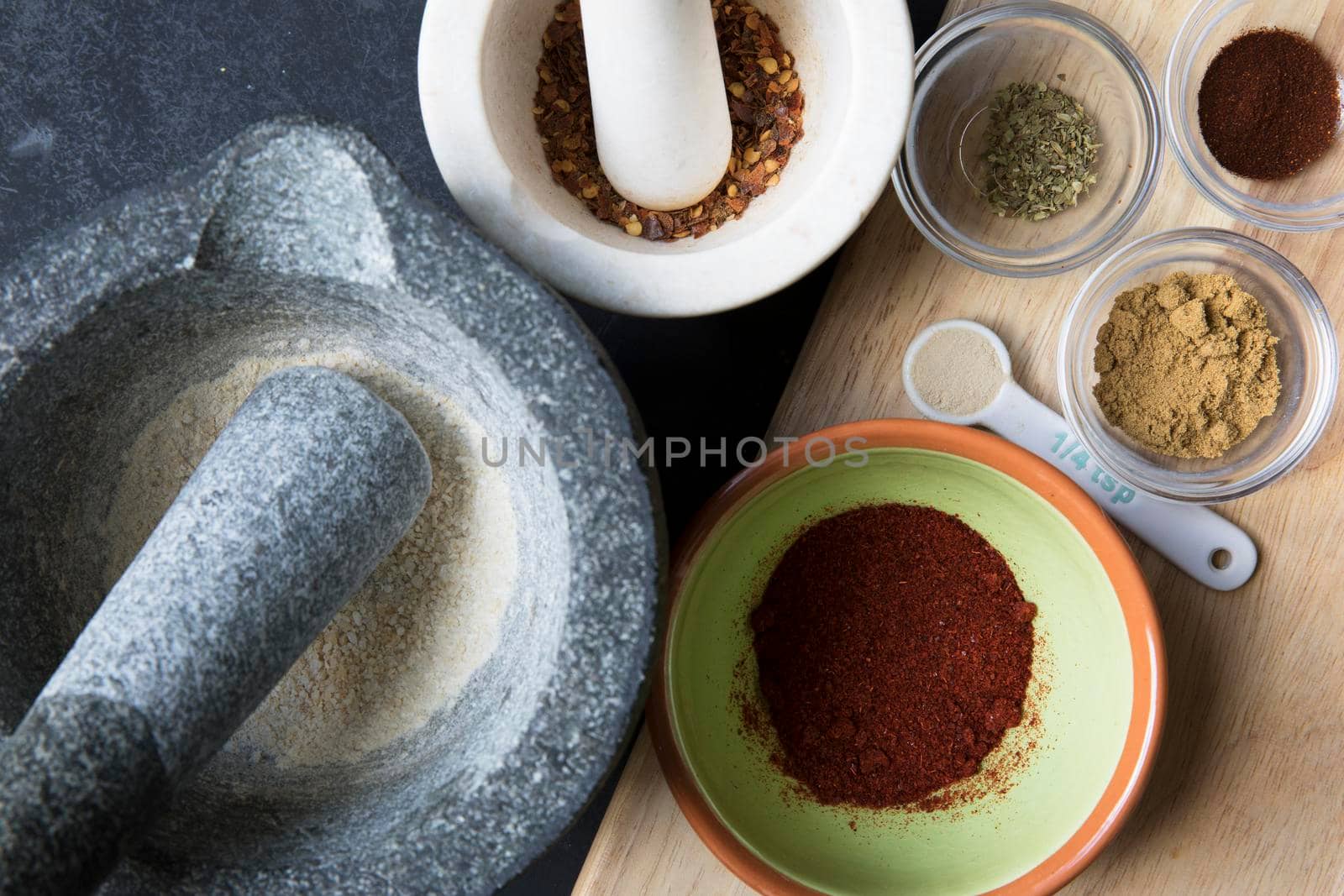 Mortar and pestle and small bowls with spices for taco seasoning.