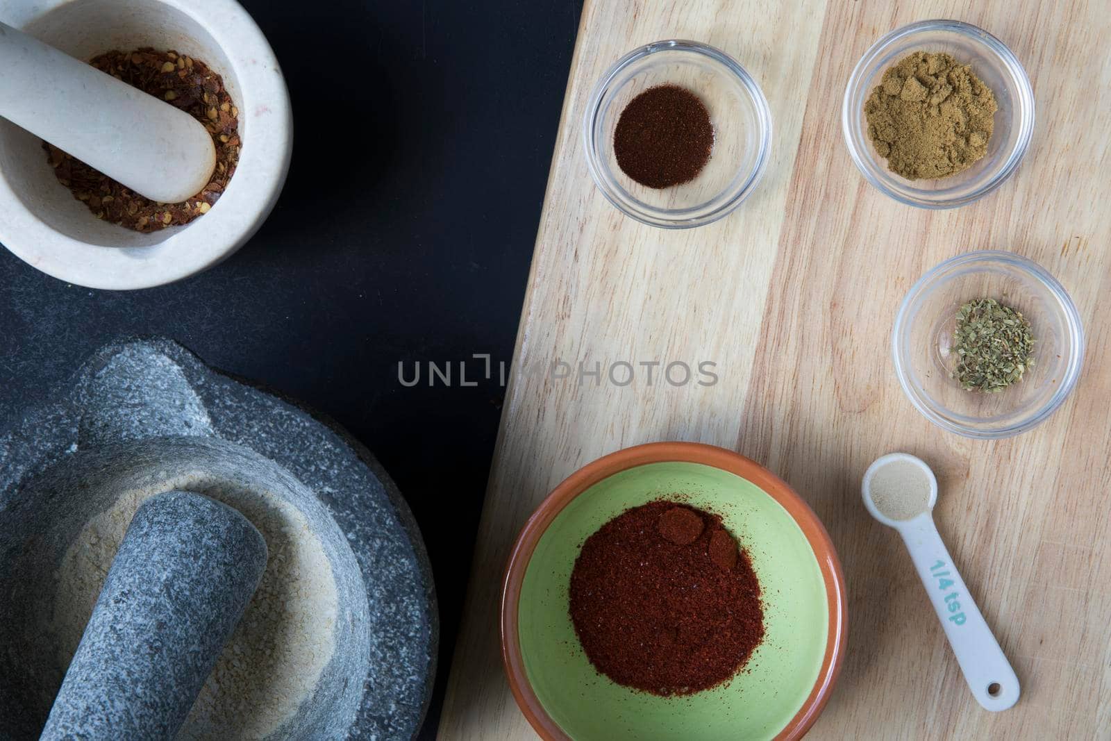 Mortar and pestle and small bowls with spices for taco seasoning.