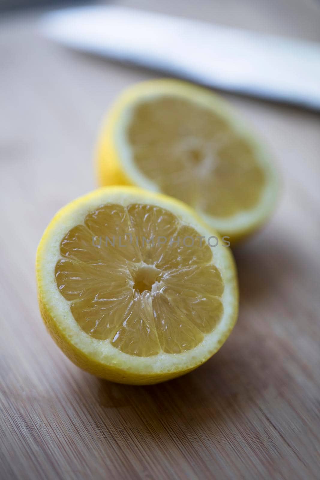 Fresh lemon cut in half with shallow depth of field and vertical orientation.