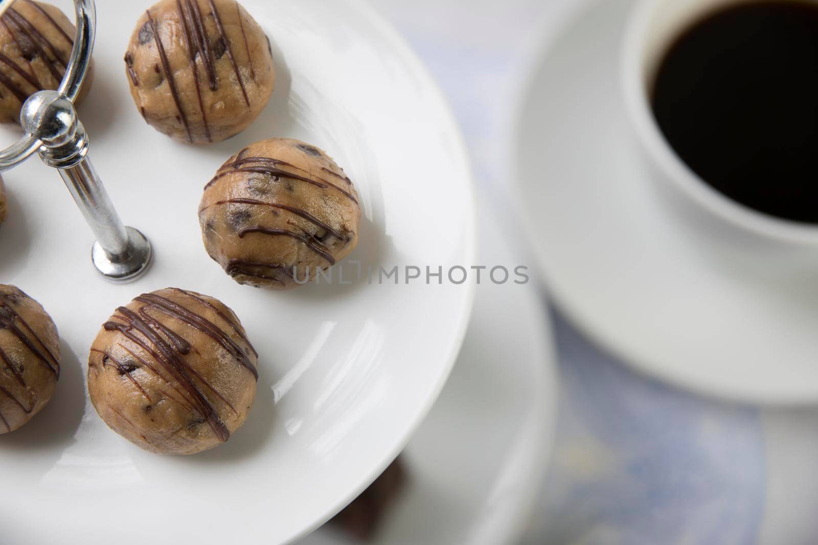 Cookie dough style chocolate treats on pastry tower with coffee in background