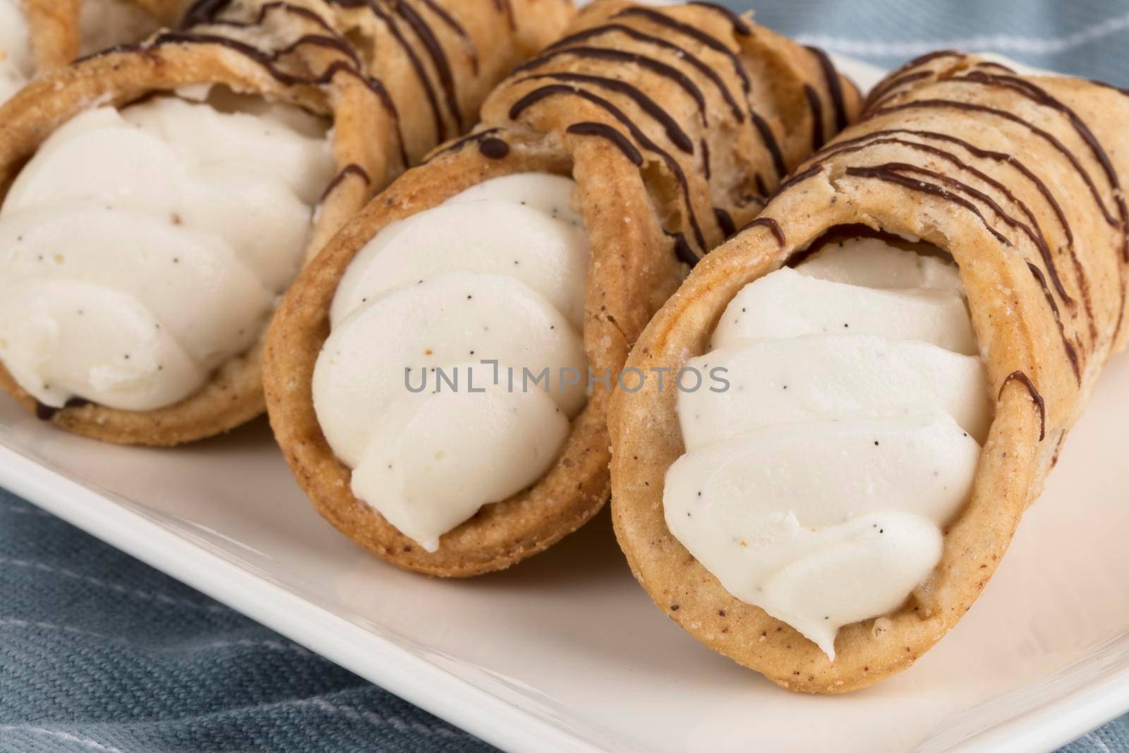 Close up of pastries Stuffed with sweet cream and drizzled with chocolate.