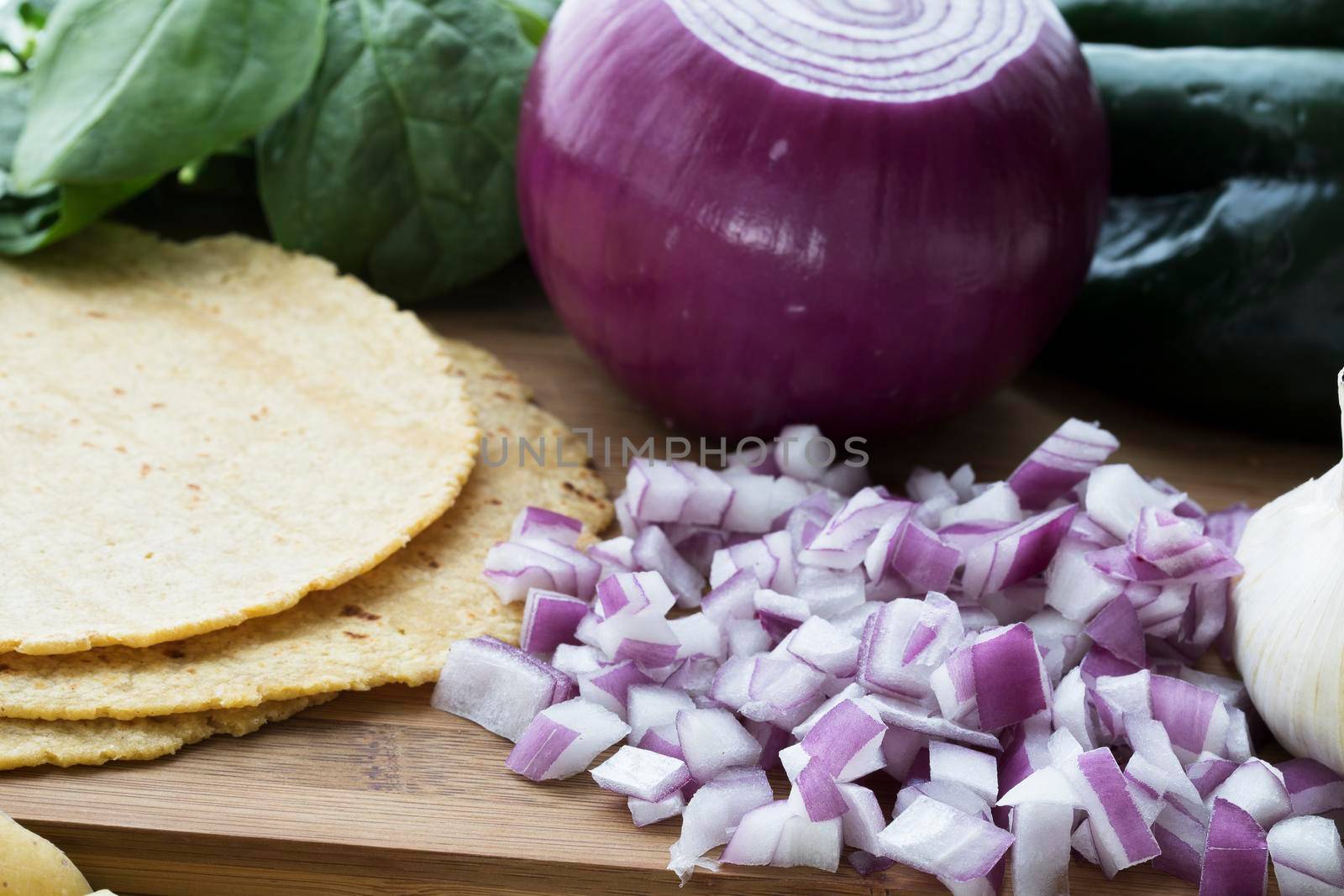Chopped red onions with corn tortillas and other ingredients.