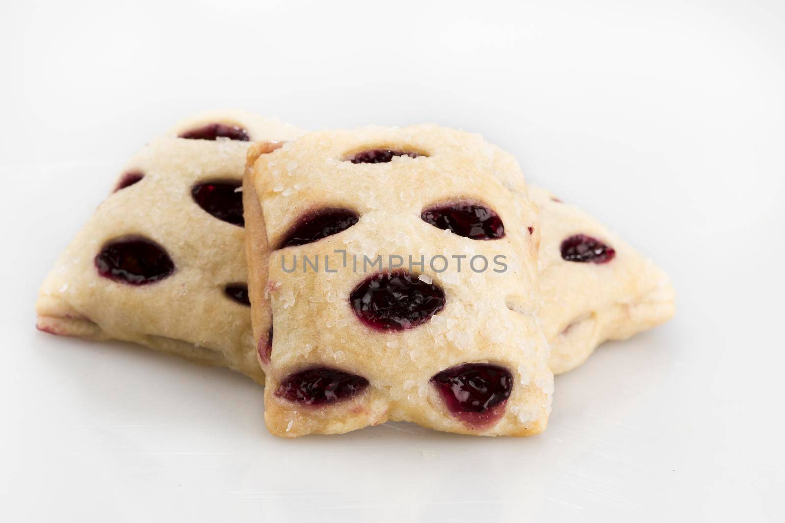 Three berry filled mini strudels on a white background