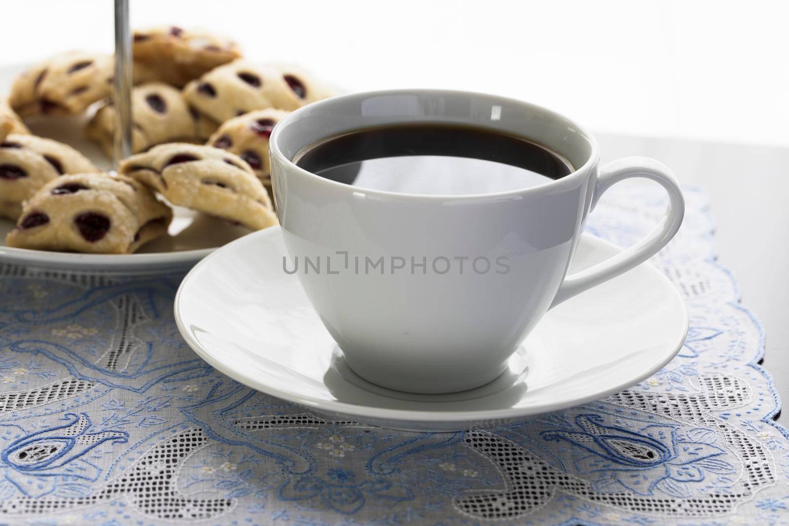 Cup of coffee with fruit filled mini strudels in the background.