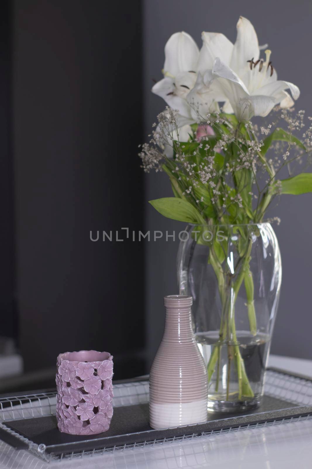 set of home decoration - candle, vase and flowers - on a handmade black metal tray at the kitchen. home interior concept by oliavesna