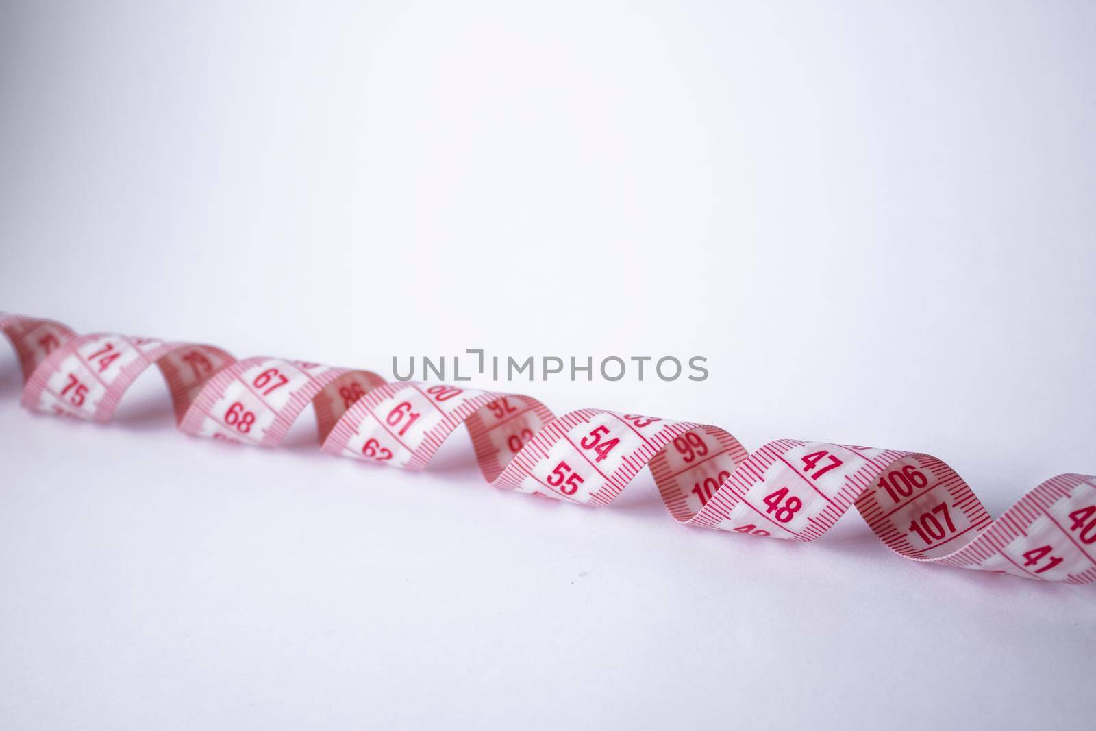 Red measuring tape on white background. Loss weight concept. Top view. Copy space. Isolated. . High quality photo